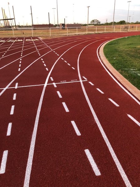 Red running track with white lane markings prepared for track certification and compliance review.
