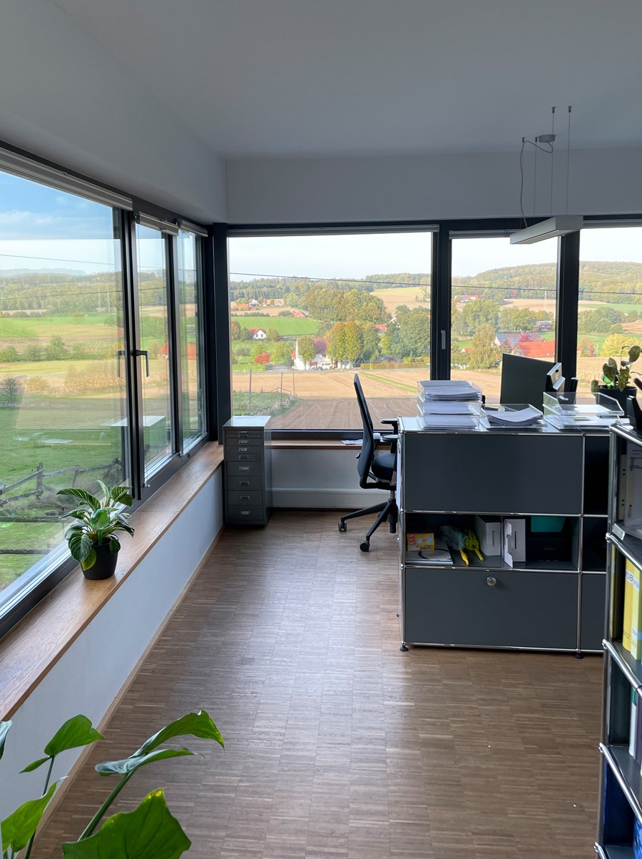 Das helle Büro von Beinker Architektur mit Panoramafenster und nachhaltiger Holzarchitektur – Beispiel für modernes Arbeiten im Grünen.