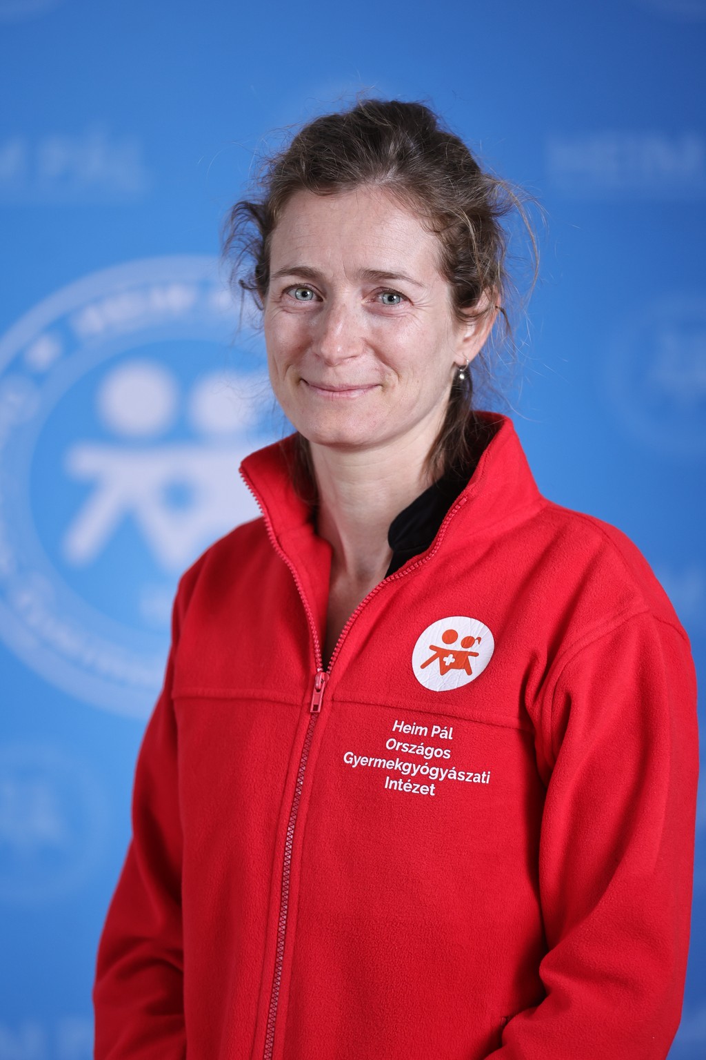 Összefogott hajú nő piros kardigánban