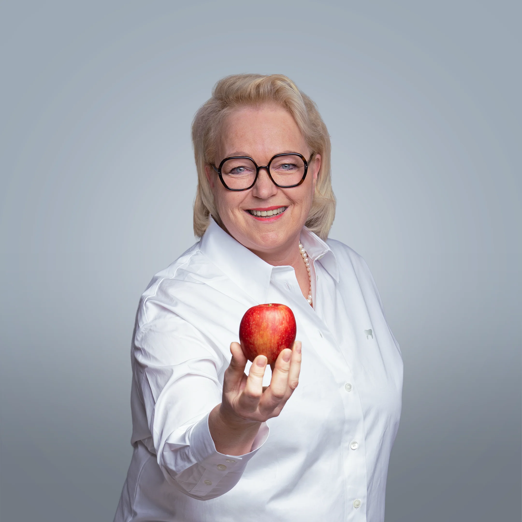 Gruppenfoto des Zahnarzt-Teams in einem Feld mit Apfelbäumen