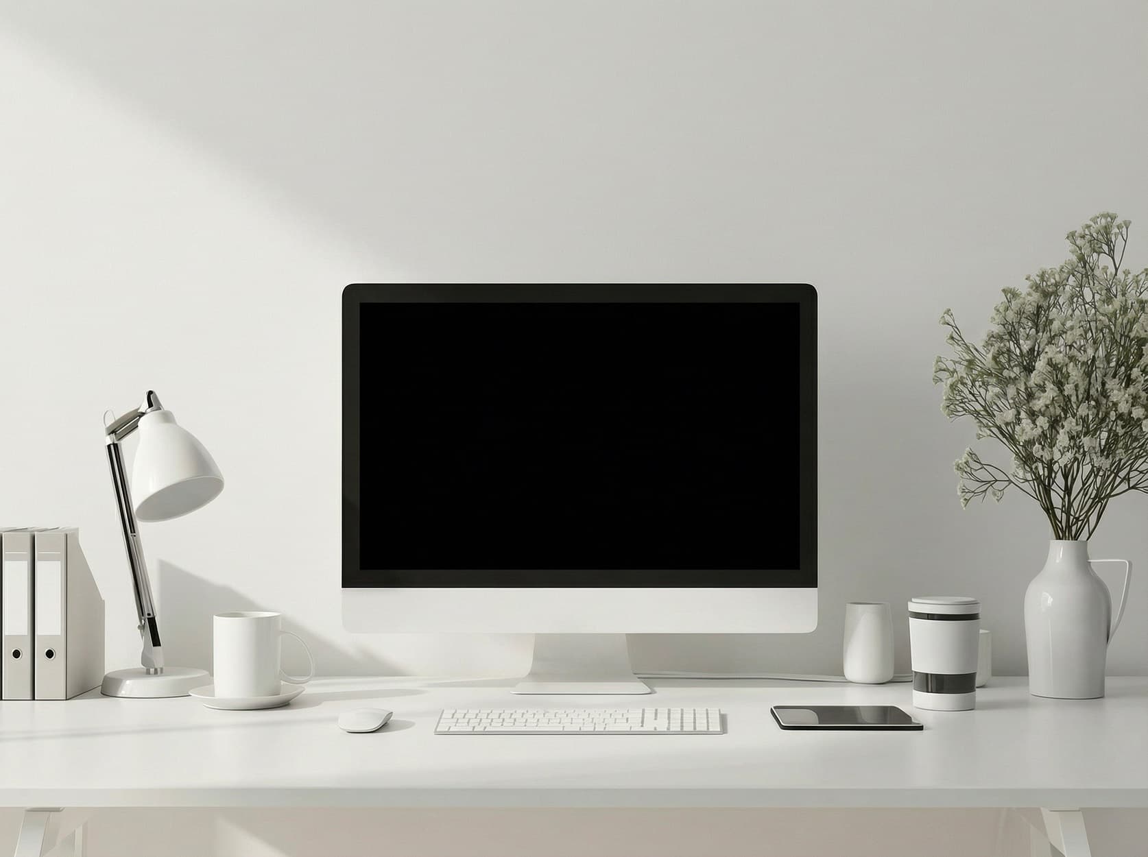 Un ordinateur Apple sur un bureau blanc, entouré d'objets blancs