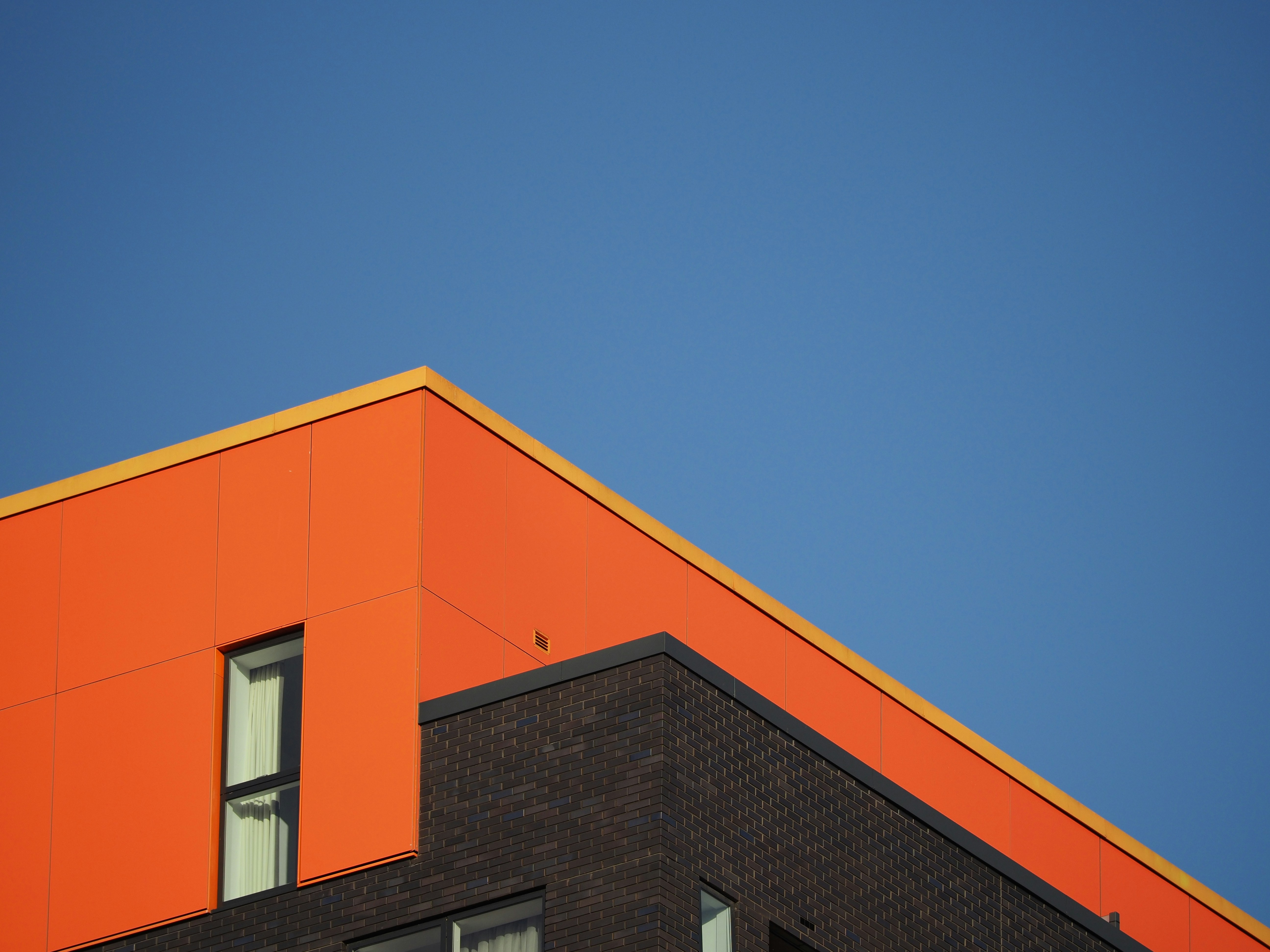 an orange building with a blue sky in the background