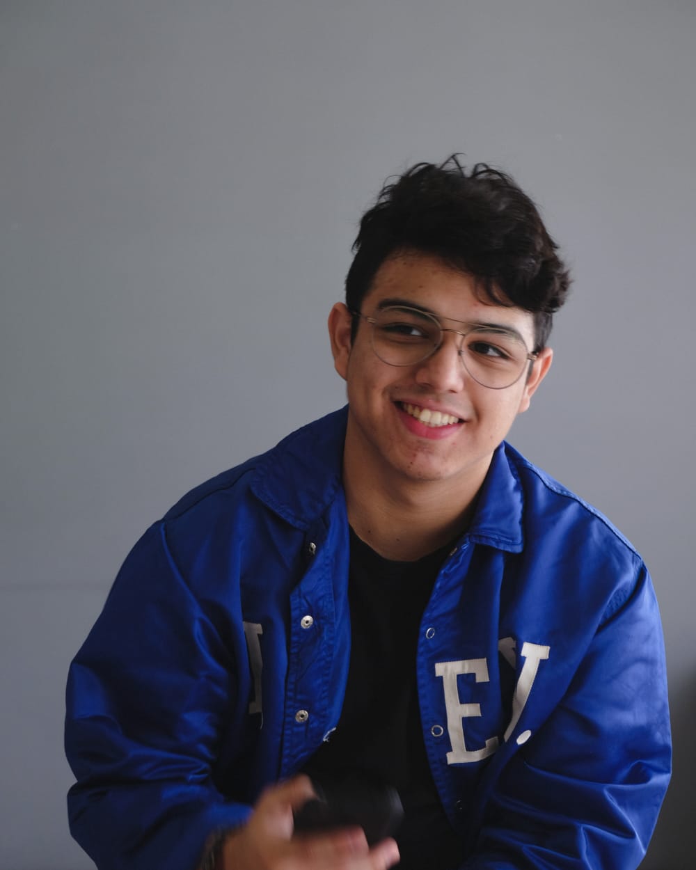 A smiling woman writing on a piece of paper in her home
