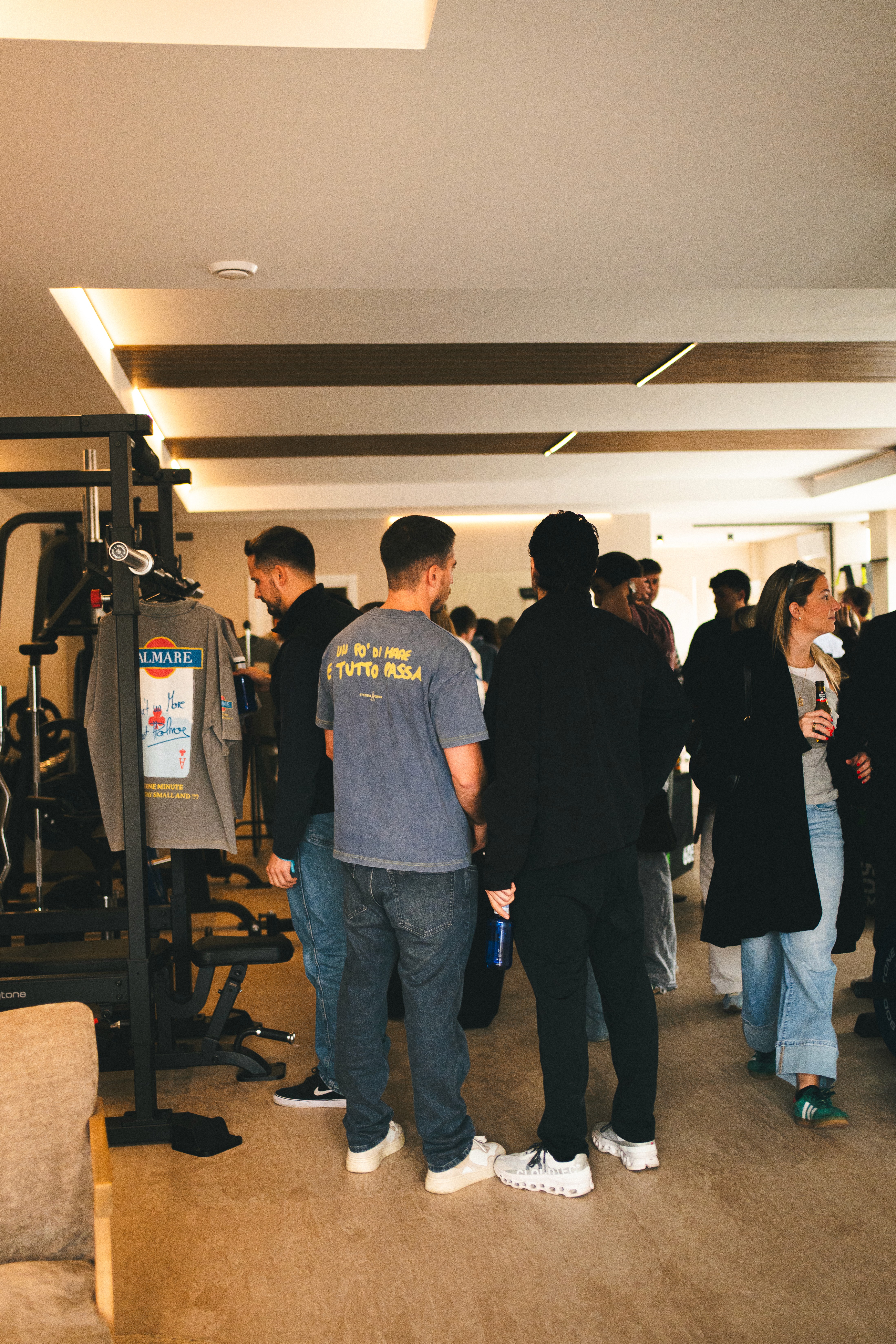 A woman wearing a shiny coat stands in focus, while a blurred background creates a sense of movement.
