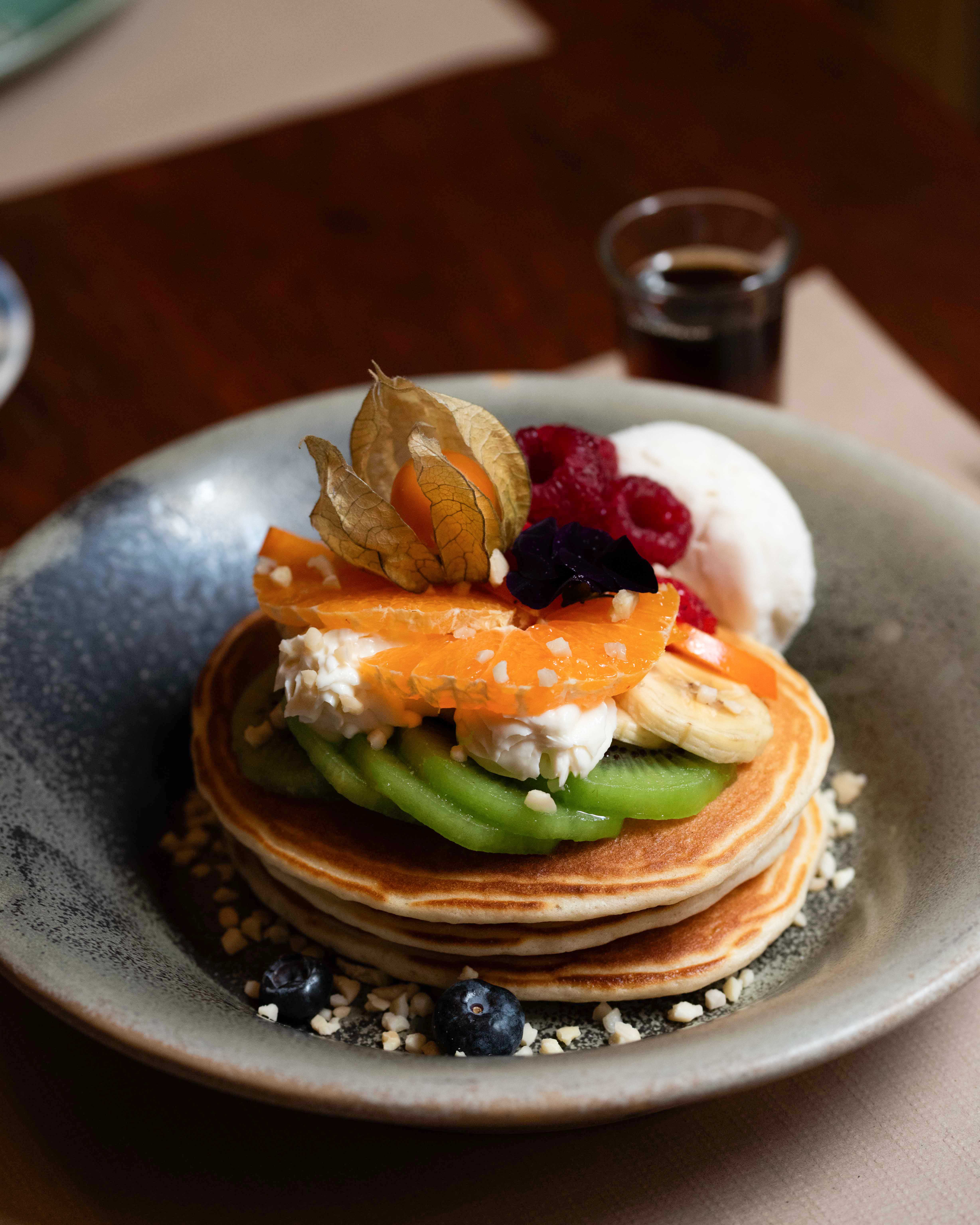 Fluffy vegetarian pancakes with seasonal fruits and ice cream at Faire. Brunch & Drinks
