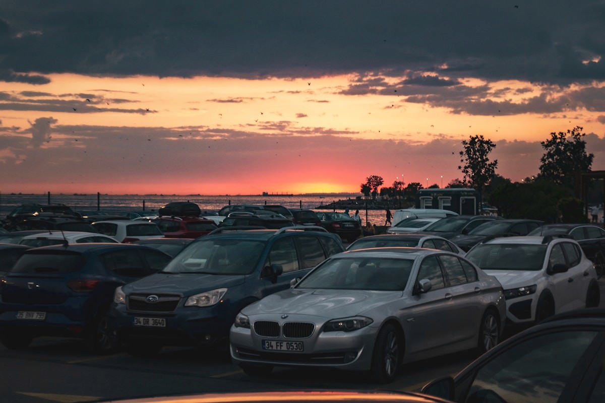 Cars parked by the water at dusk near the precinct.