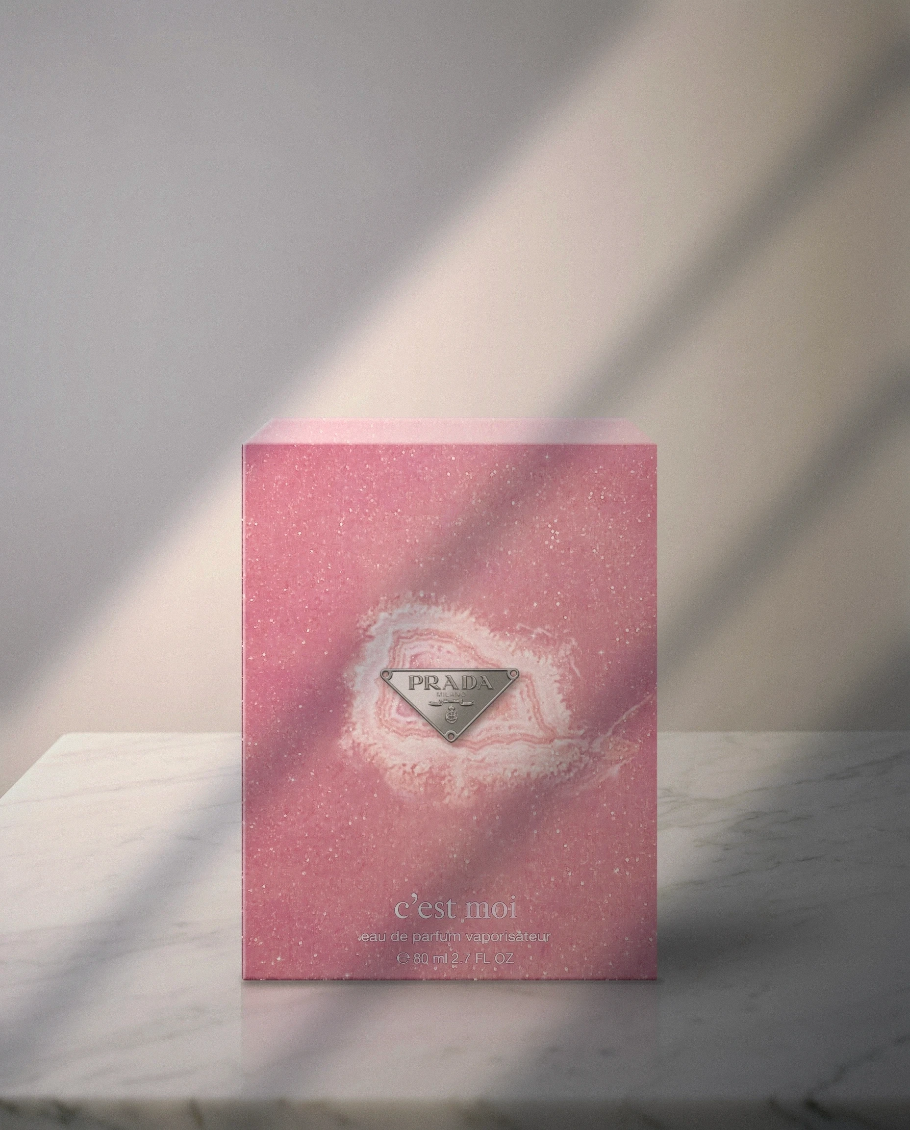 Pink c’est moi box with the silver Prada plaque on a marble surface