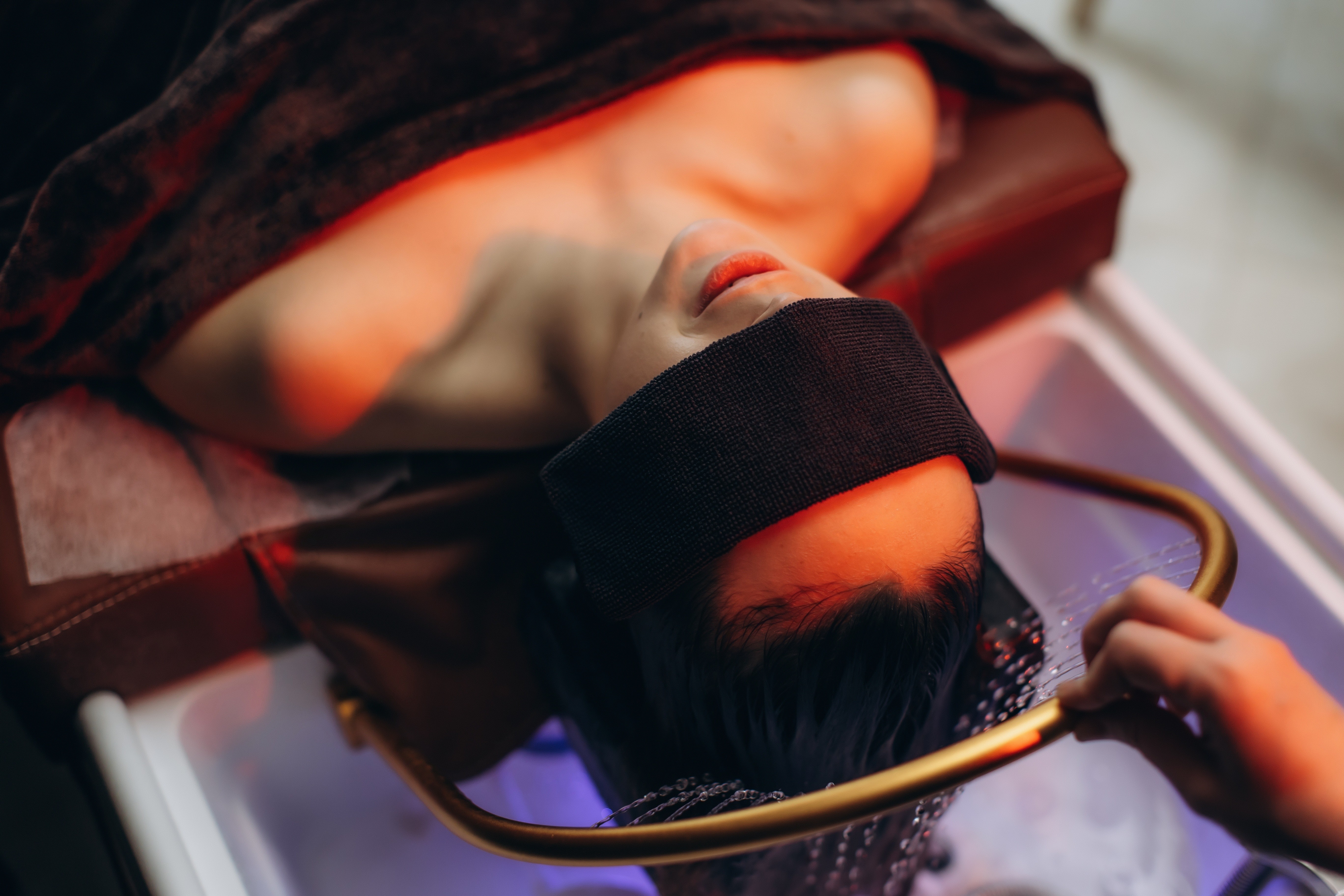 Client relaxing during a warm-water Japanese head spa rinse at Aluna Head Spa