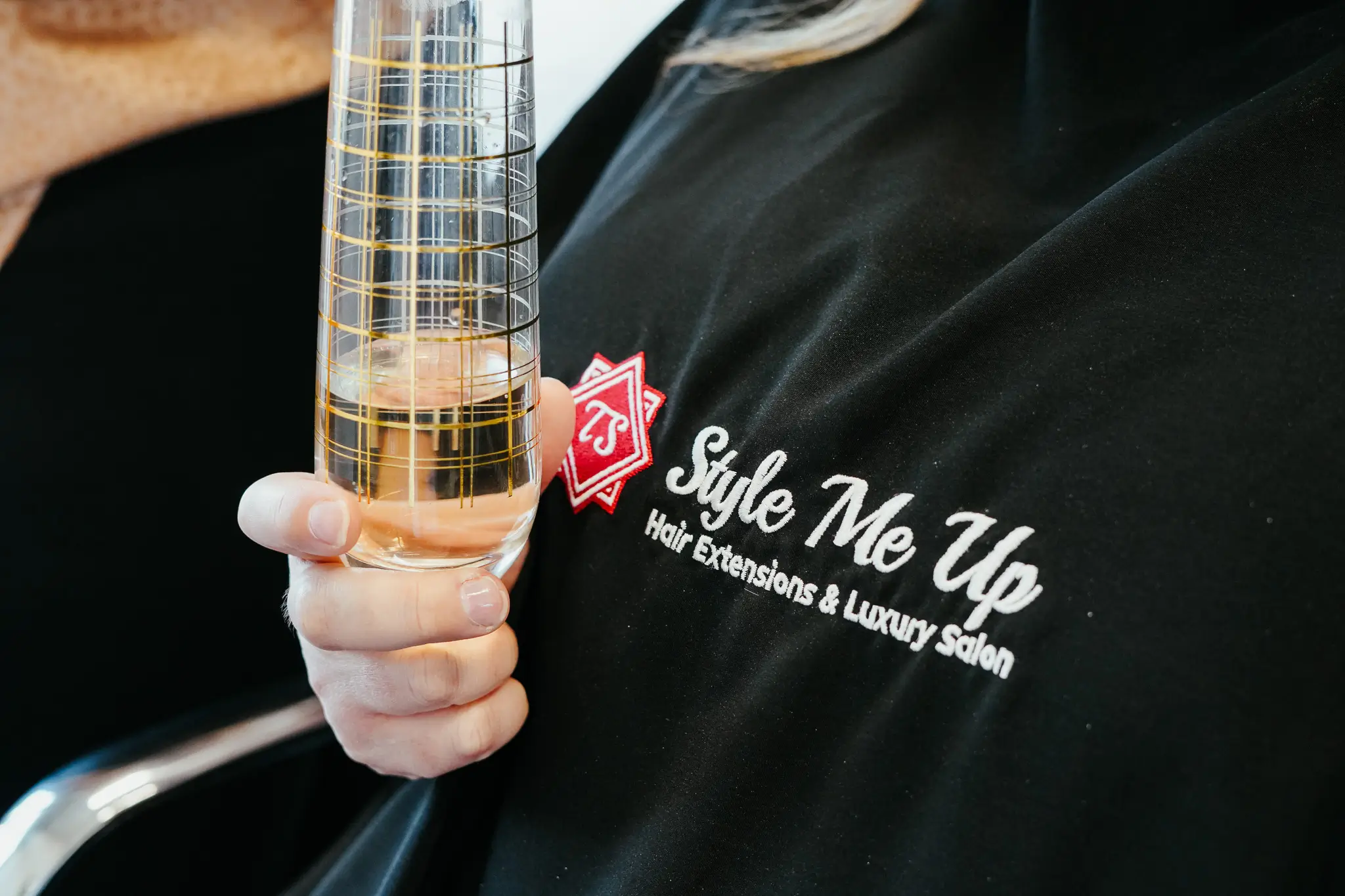 Photo of a woman wearing a Style Me Up cape holding a glass of champaign.