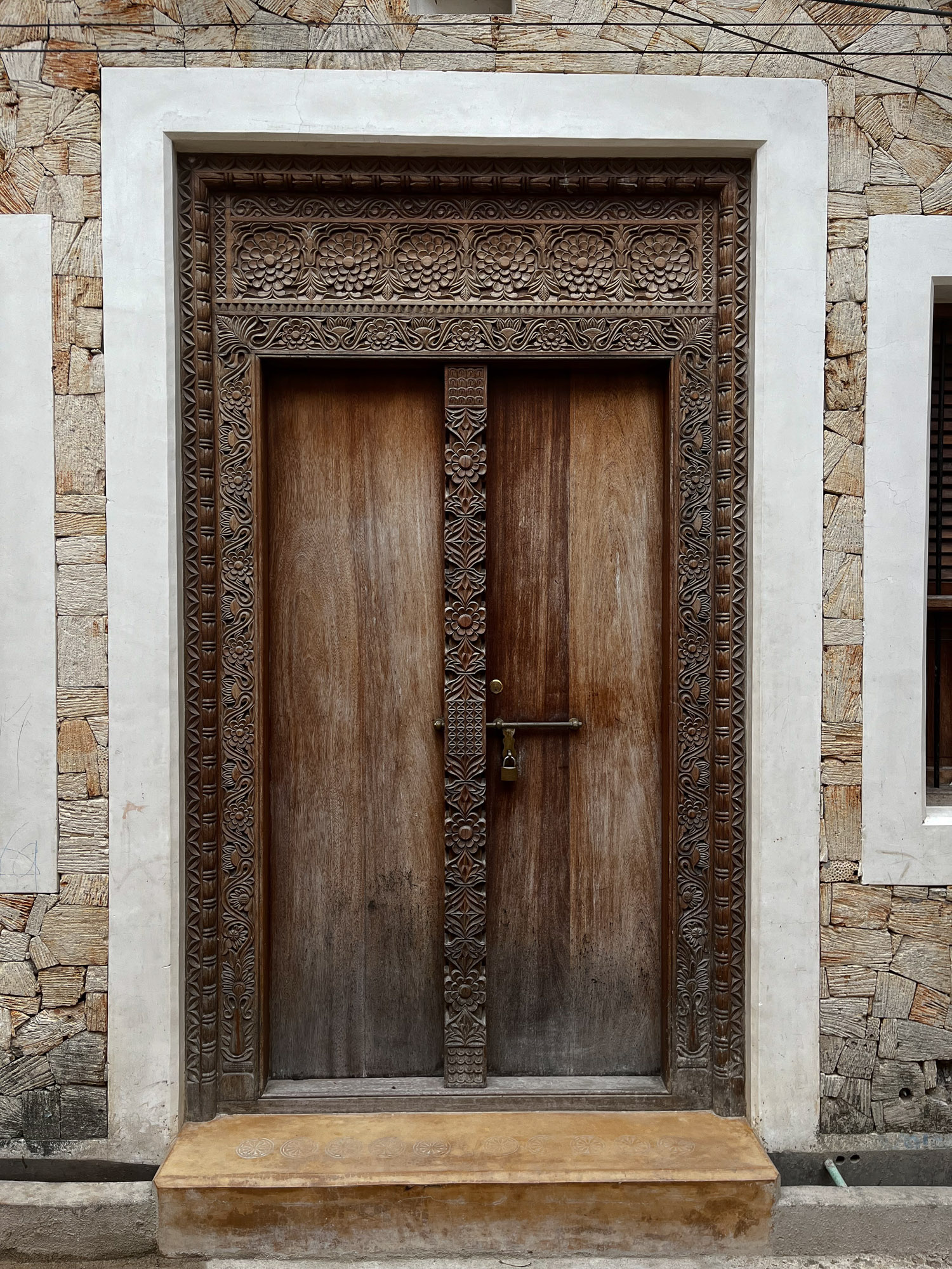 Wooden door with geometric carvings around the entry.