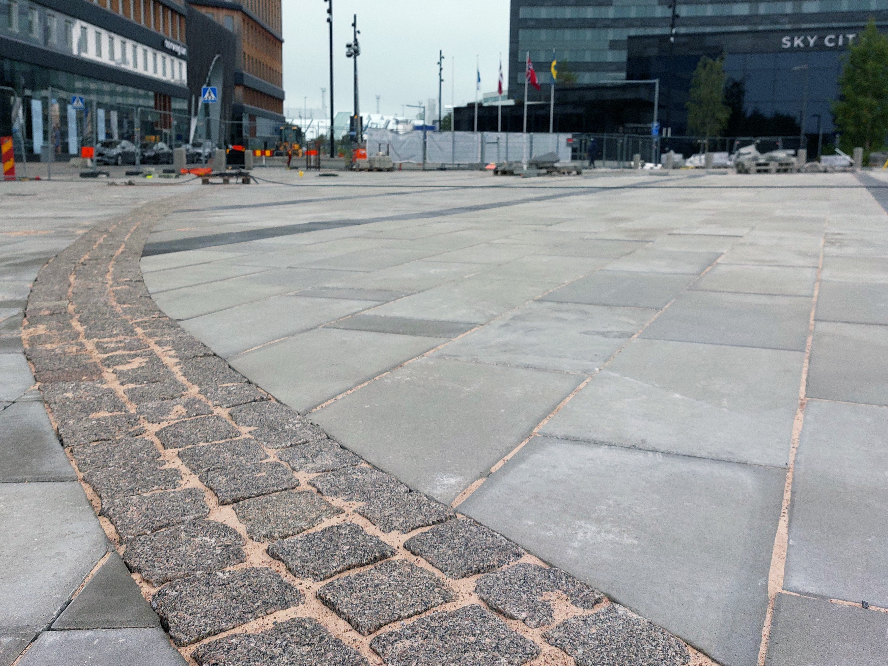 Praça pavimentada com padrão geométrico.