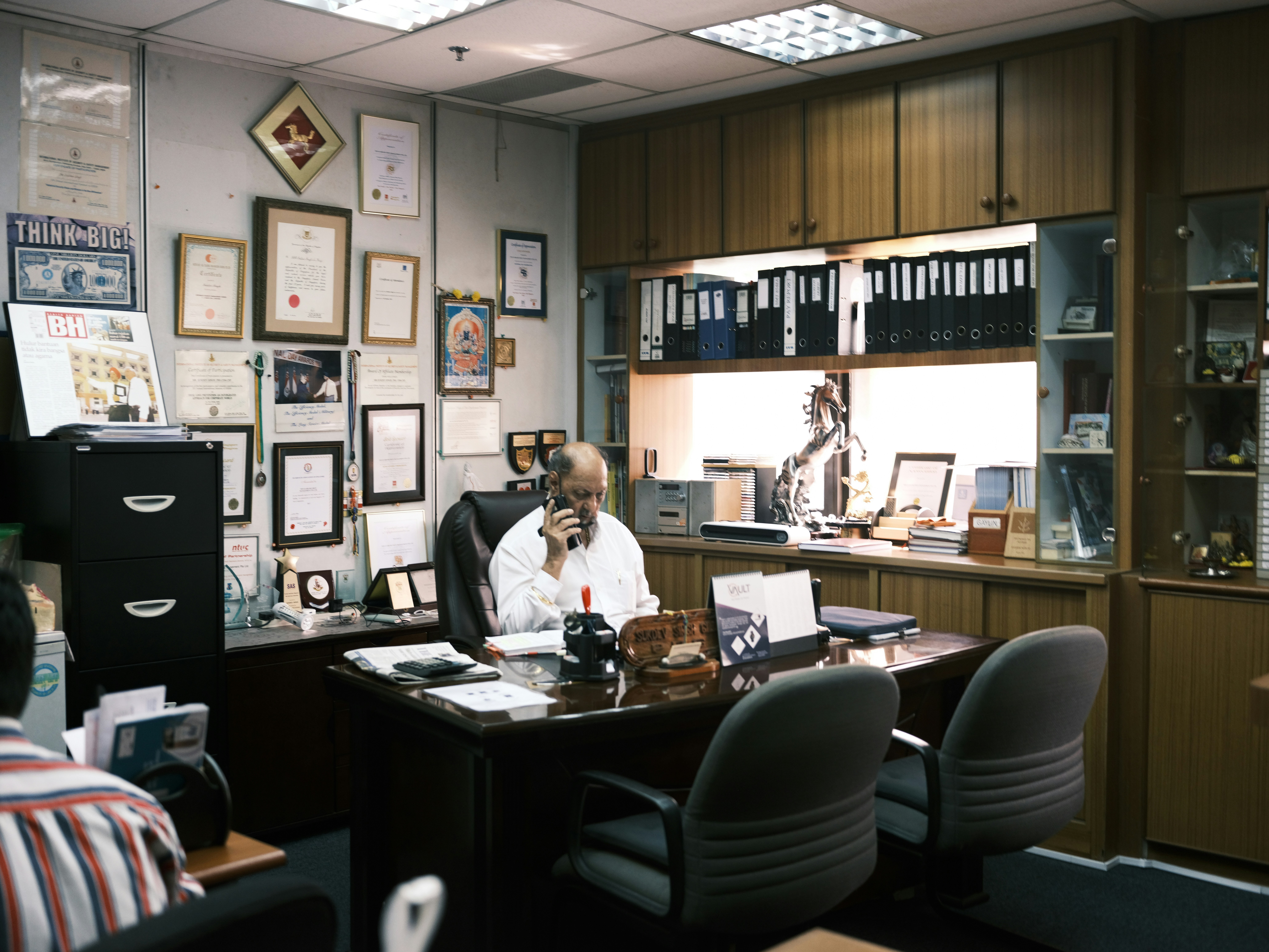 man in white dress shirt sitting on black office rolling chair
