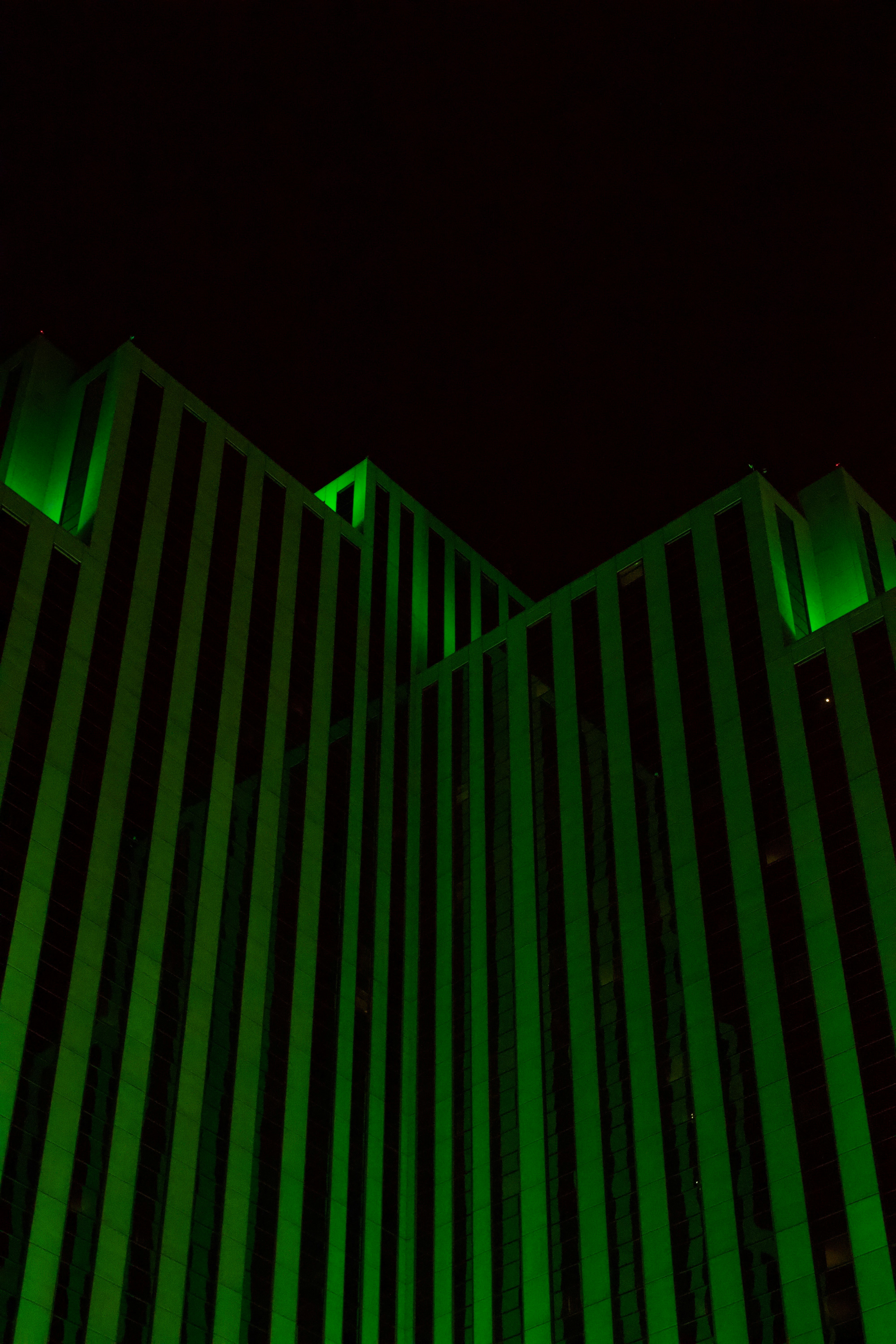 a tall building with a green light on it's side