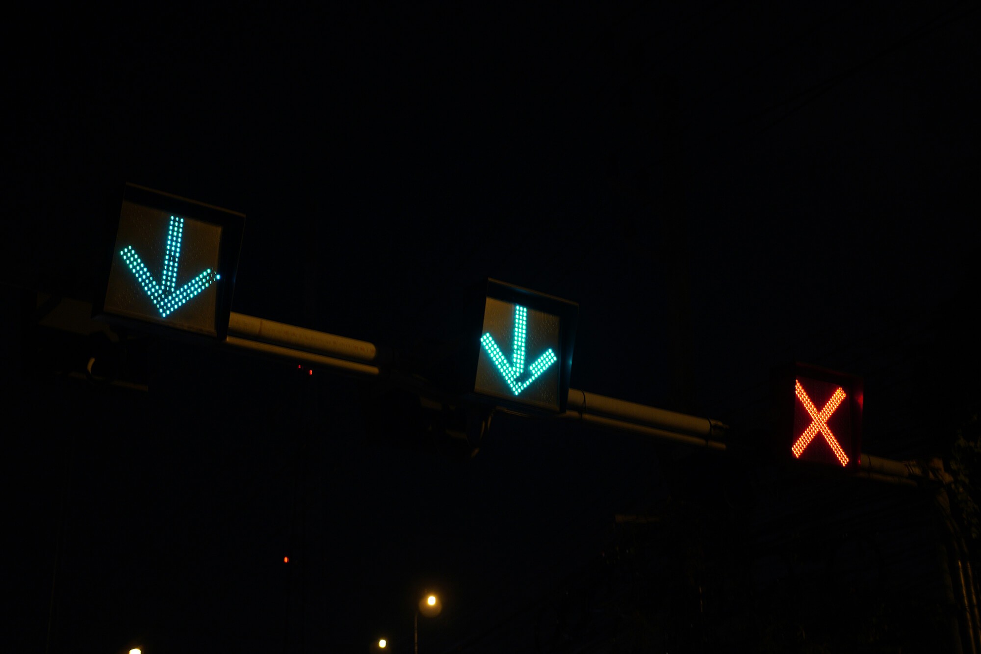 Motorway lane control signals with two green arrows and one red X.