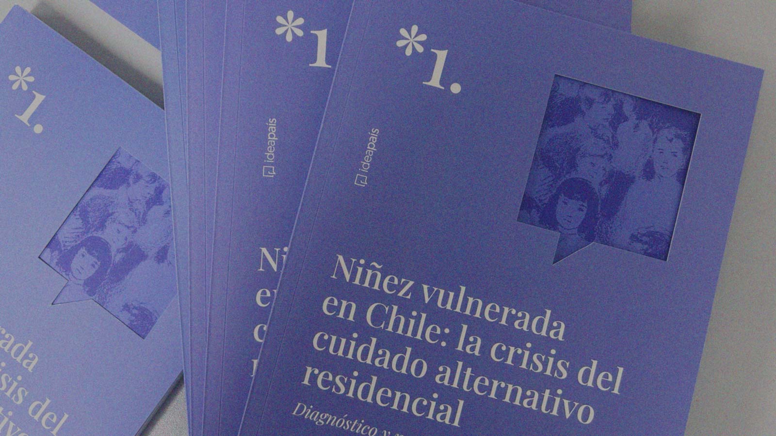 Diversos ejemplares del estudio Niñez vulnerada en Chile: la crisis del cuidado alternatvio residencial, sobre una mesa, en noticia de IdeaPaís.