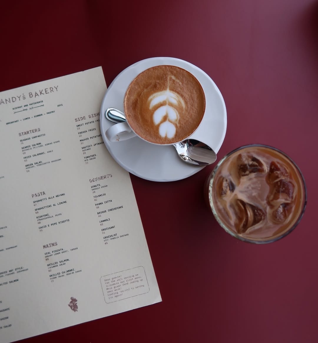 Two specialty coffees on an outdoor table with stylish surroundings.