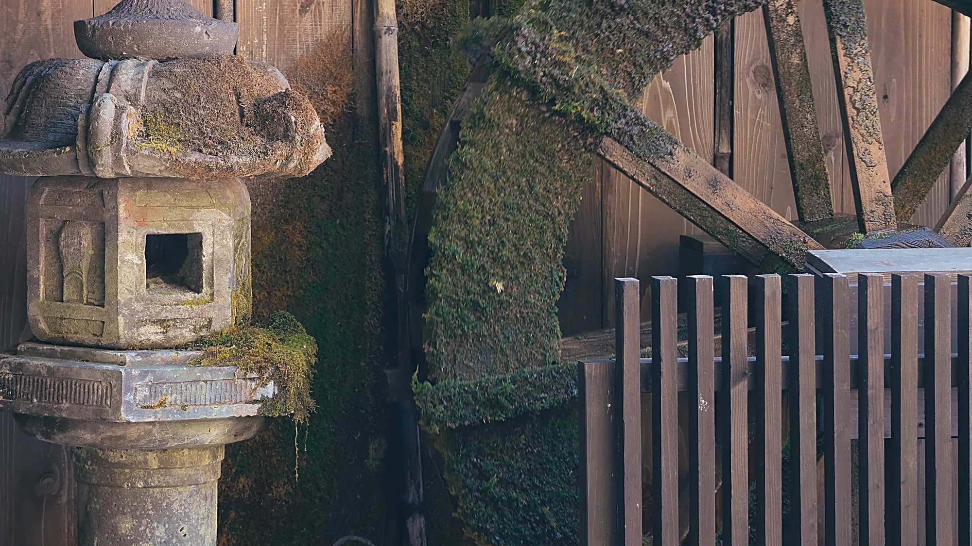 Inns above the covered walkway at Kurokawa Onsen, a cedar slope rising behind