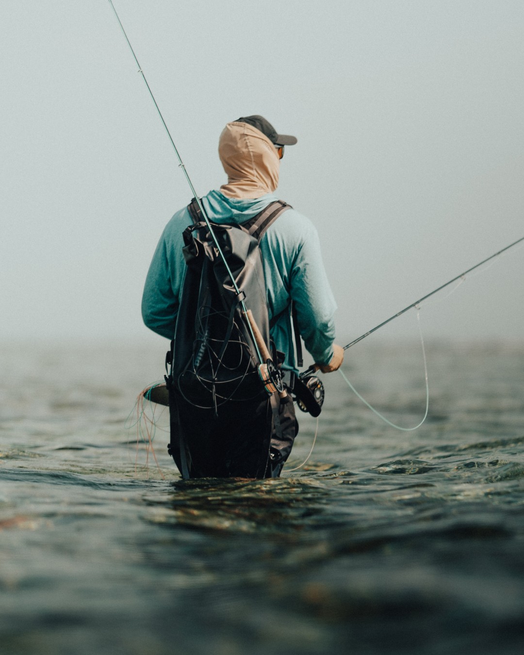 Saltwater angler vading in knee deep water on shallow flats in Belize