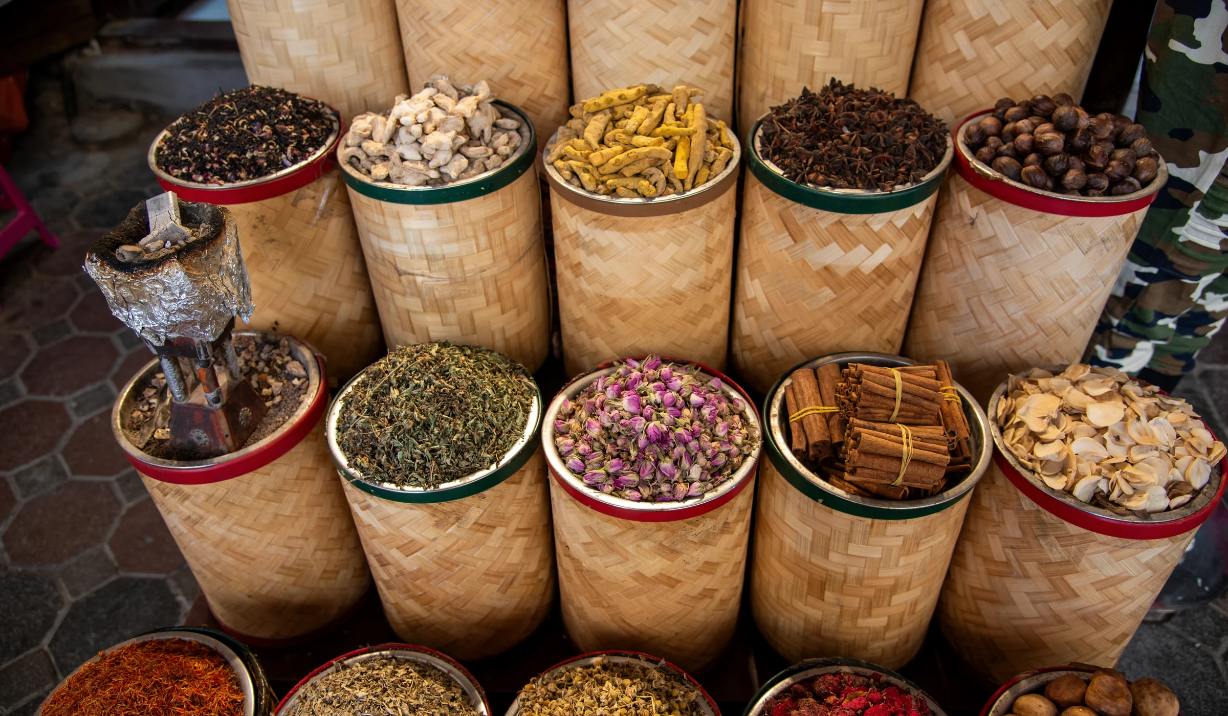 Spice market with rosebuds, turmeric, cinnamon, herbs and woven baskets