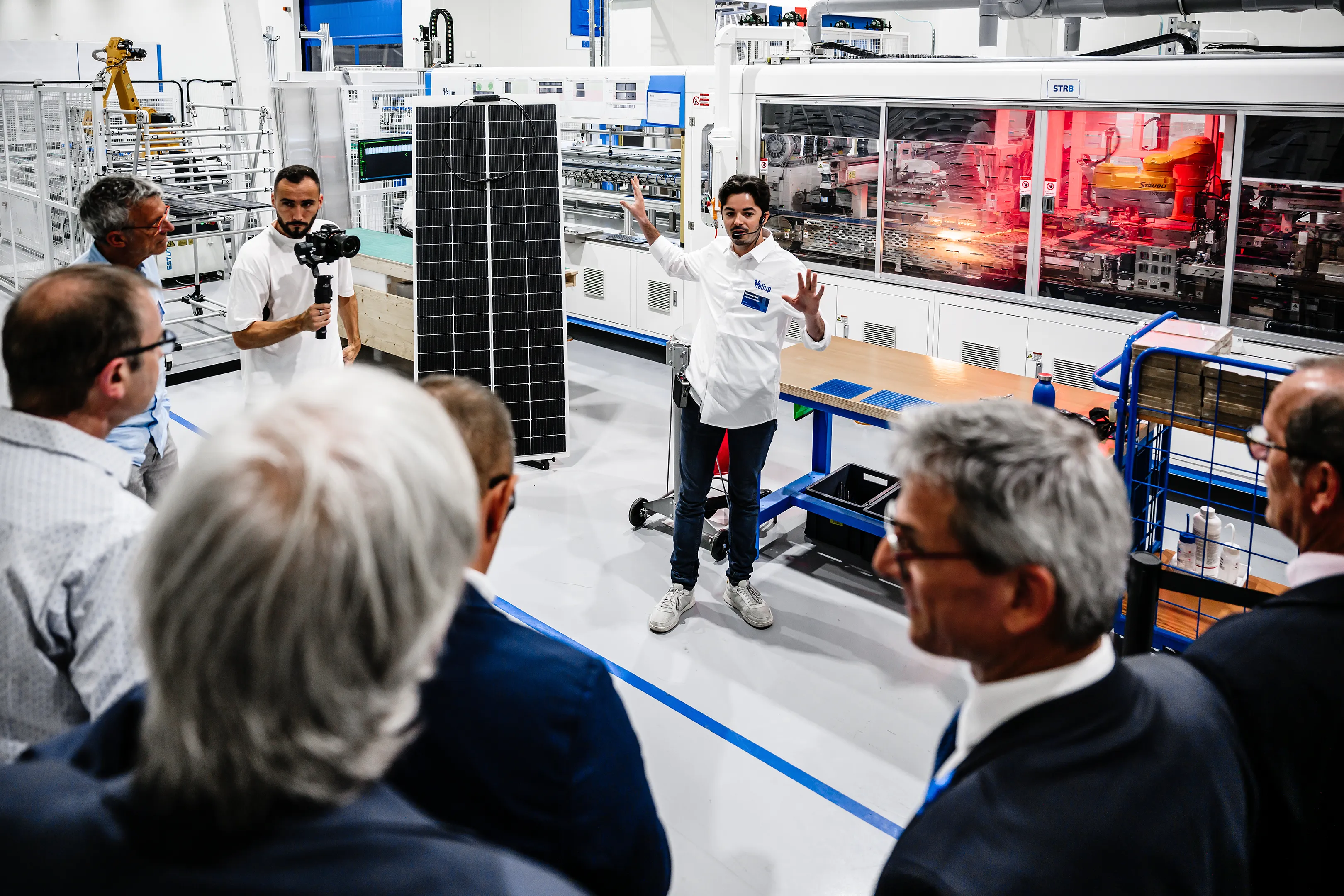 Présentation d’une ligne de production de panneaux photovoltaïques à des invités lors d’une inauguration