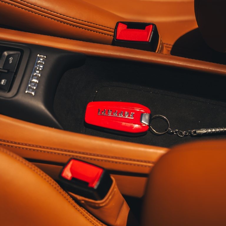 Close-up of the Ferrari F8 Spyder's keys and premium tan leather interior details.