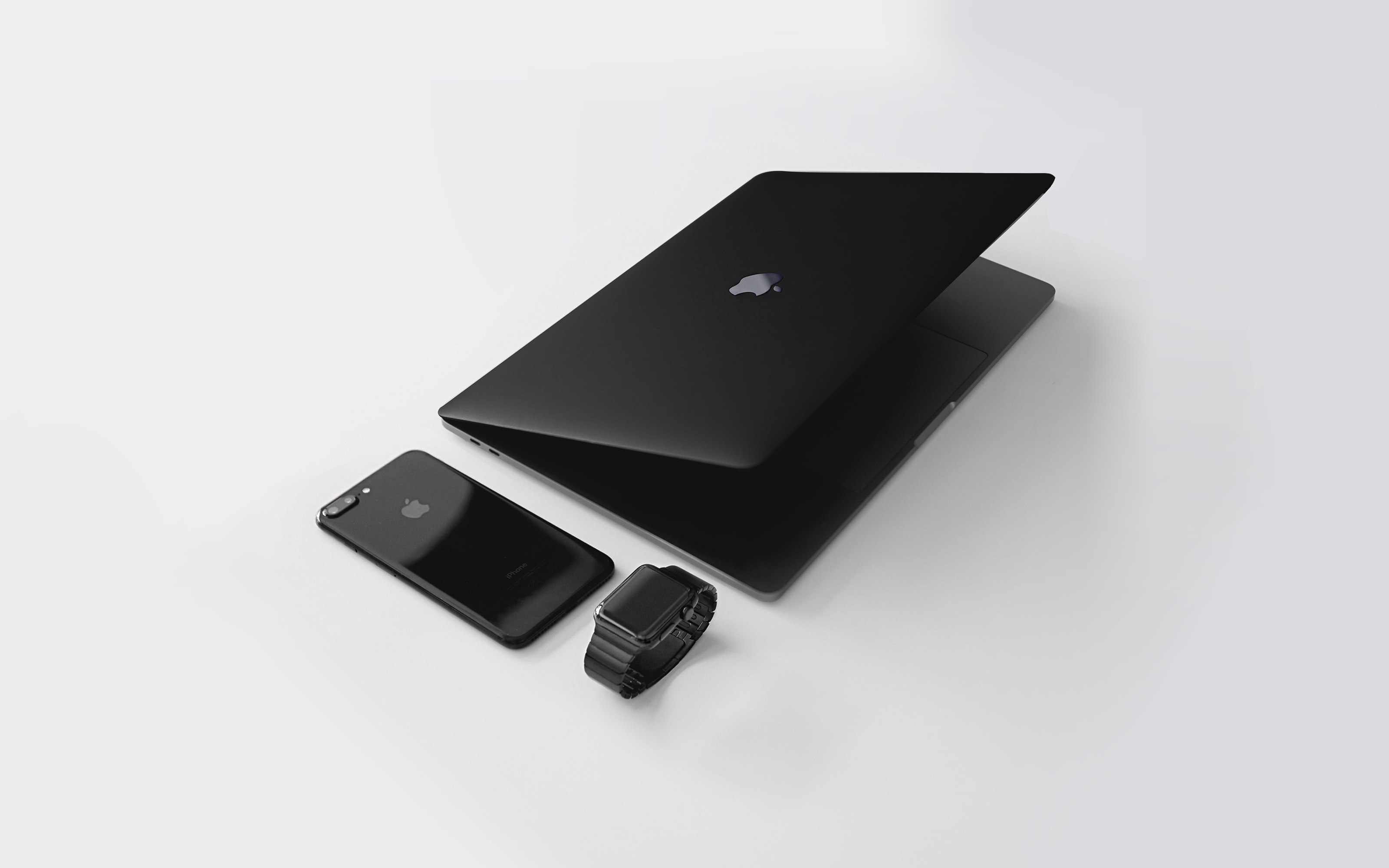 Black MacBook and iPhone on a table