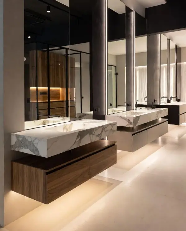 Έπιπλα μπάνιου με marble νιπτήρα και ξύλινη βάση σε σύγχρονο showroom με minimal αρχιτεκτονική