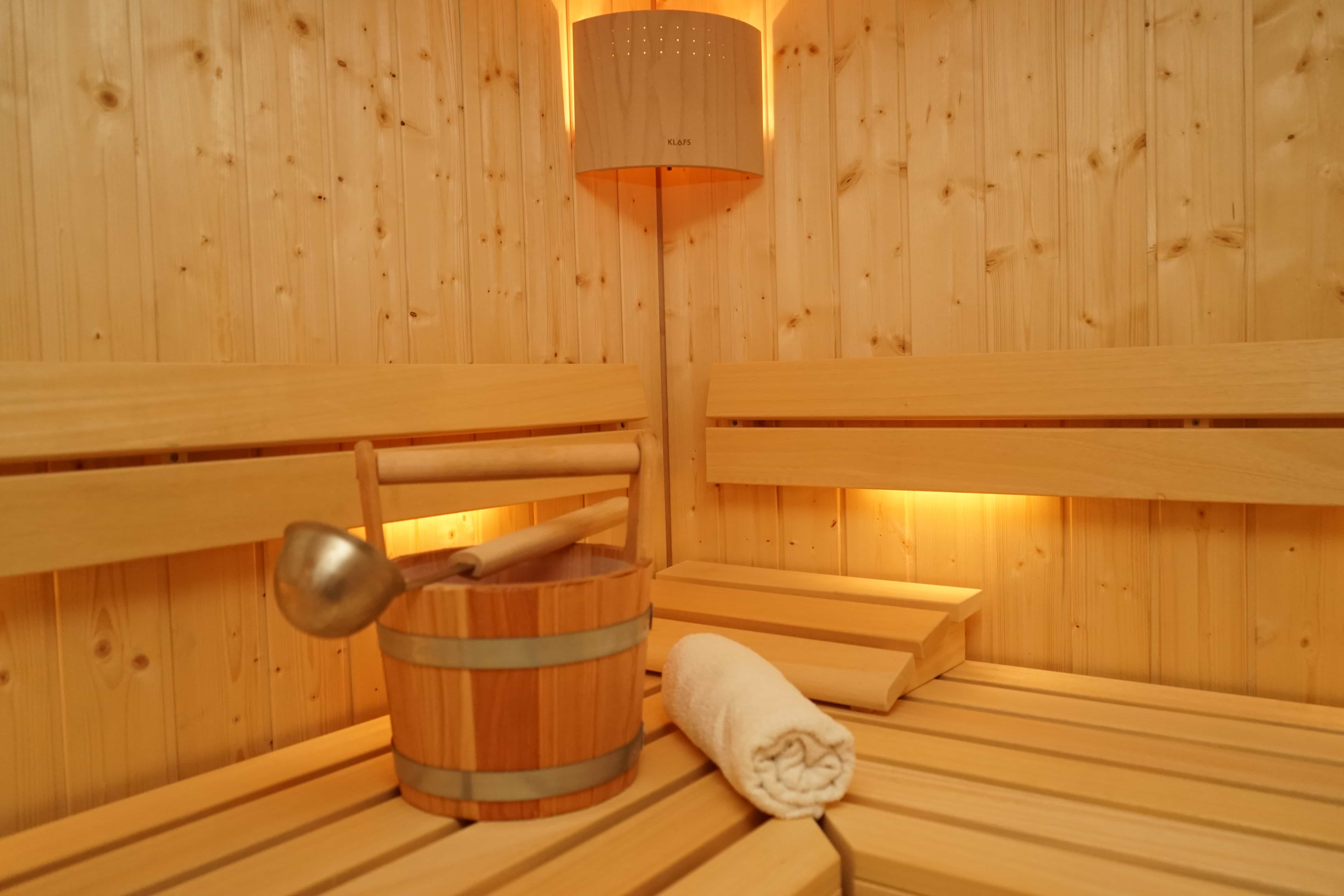 Finische Sauna mit Aufgußeimer und Handtuch