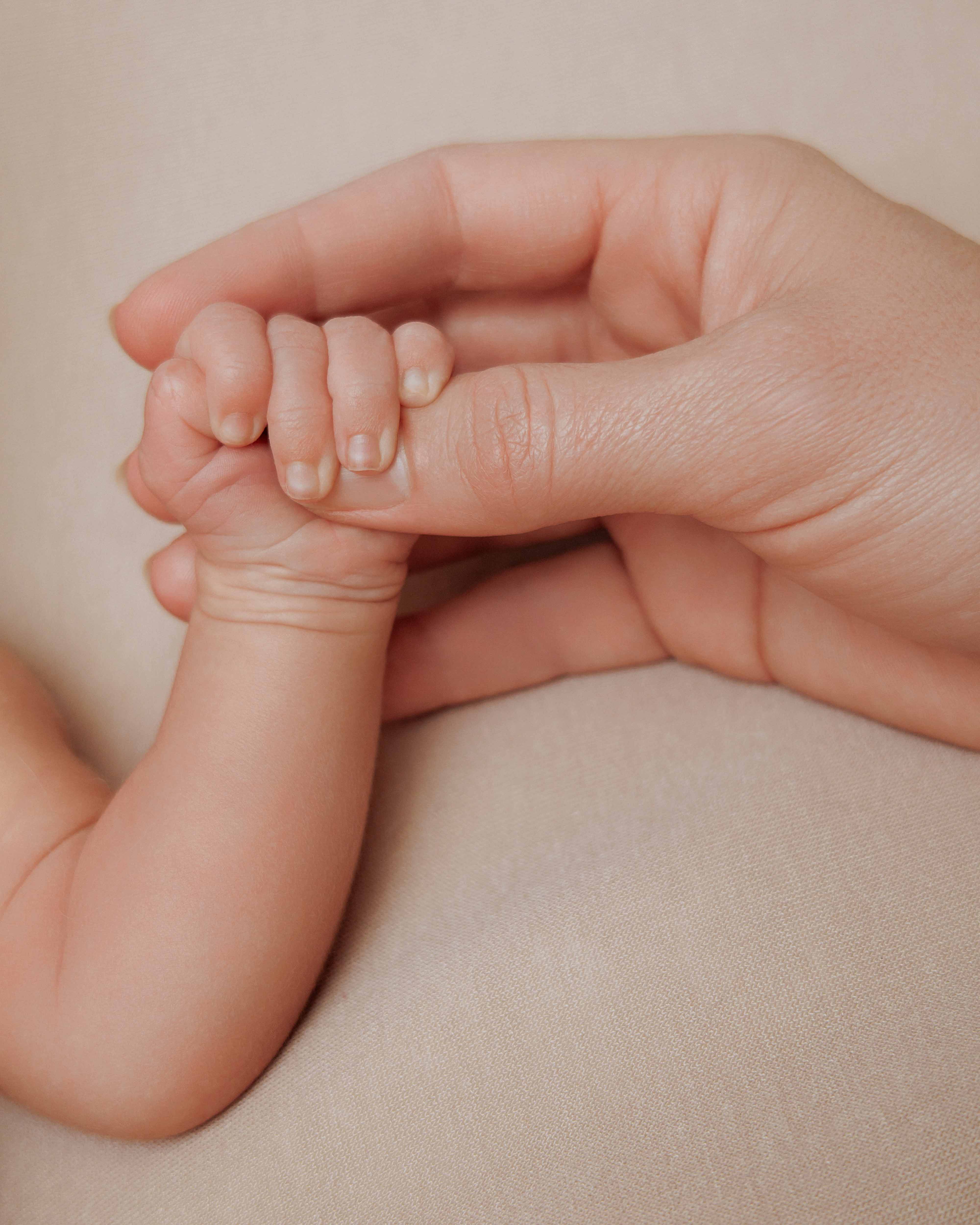 Close-up newborn photography — tiny hands and delicate skin details