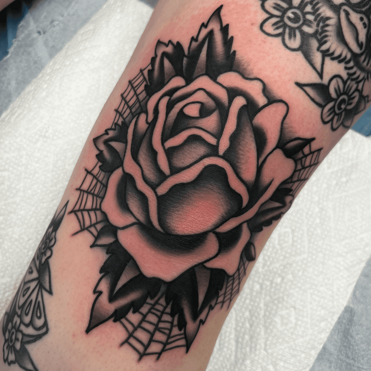 black and gray tattoo of a rose