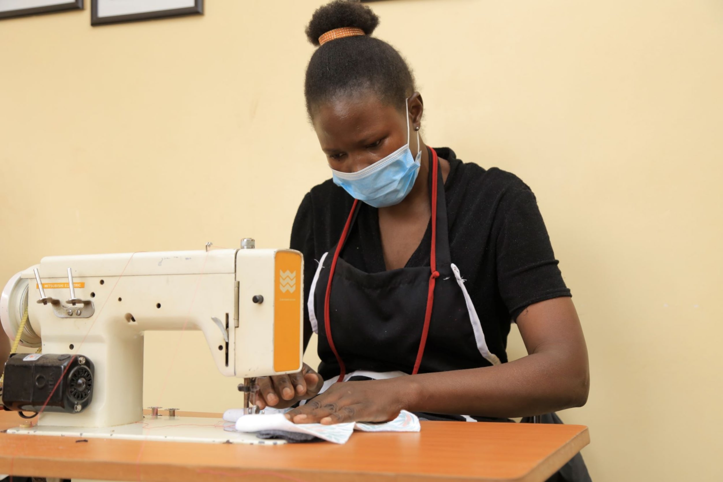 Joyce sewing a SHE FOR SHE pad with a sewing machine