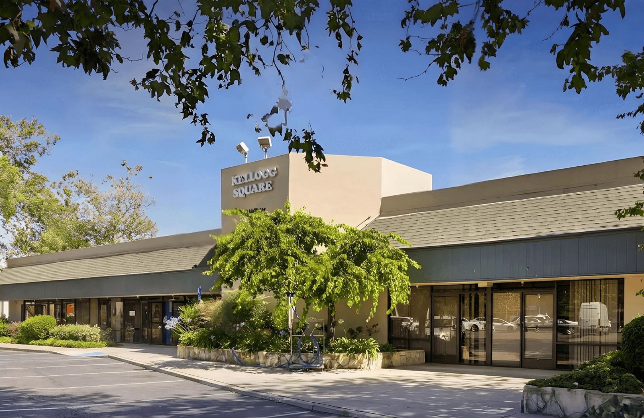 Shopping center with ground-floor shops and ample parking for customers.