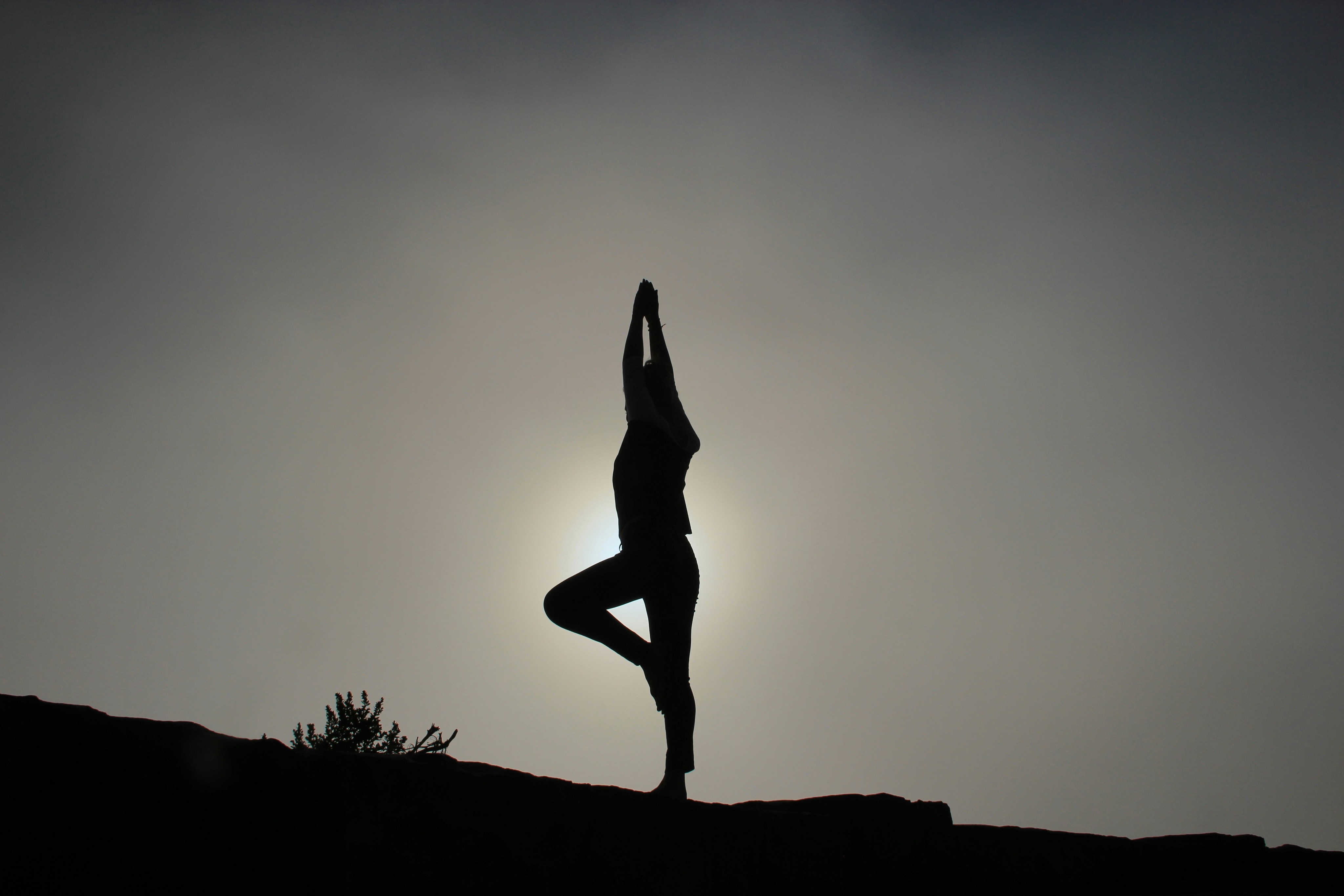 silueta de mujer realizando postura de yoga