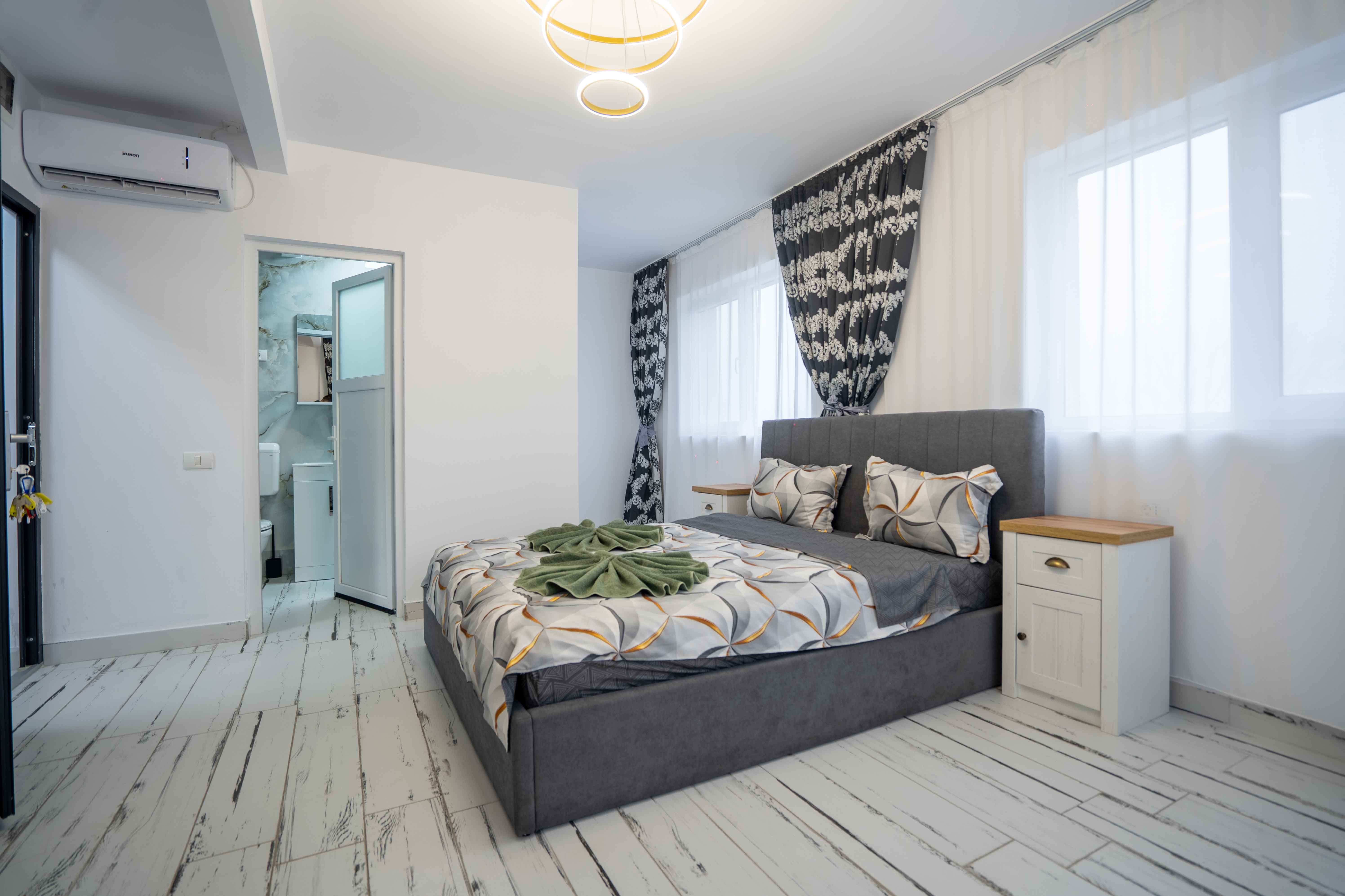 Modern bathroom featuring a walk-in shower, wooden vanity, round mirror, and elegant marble tiles.