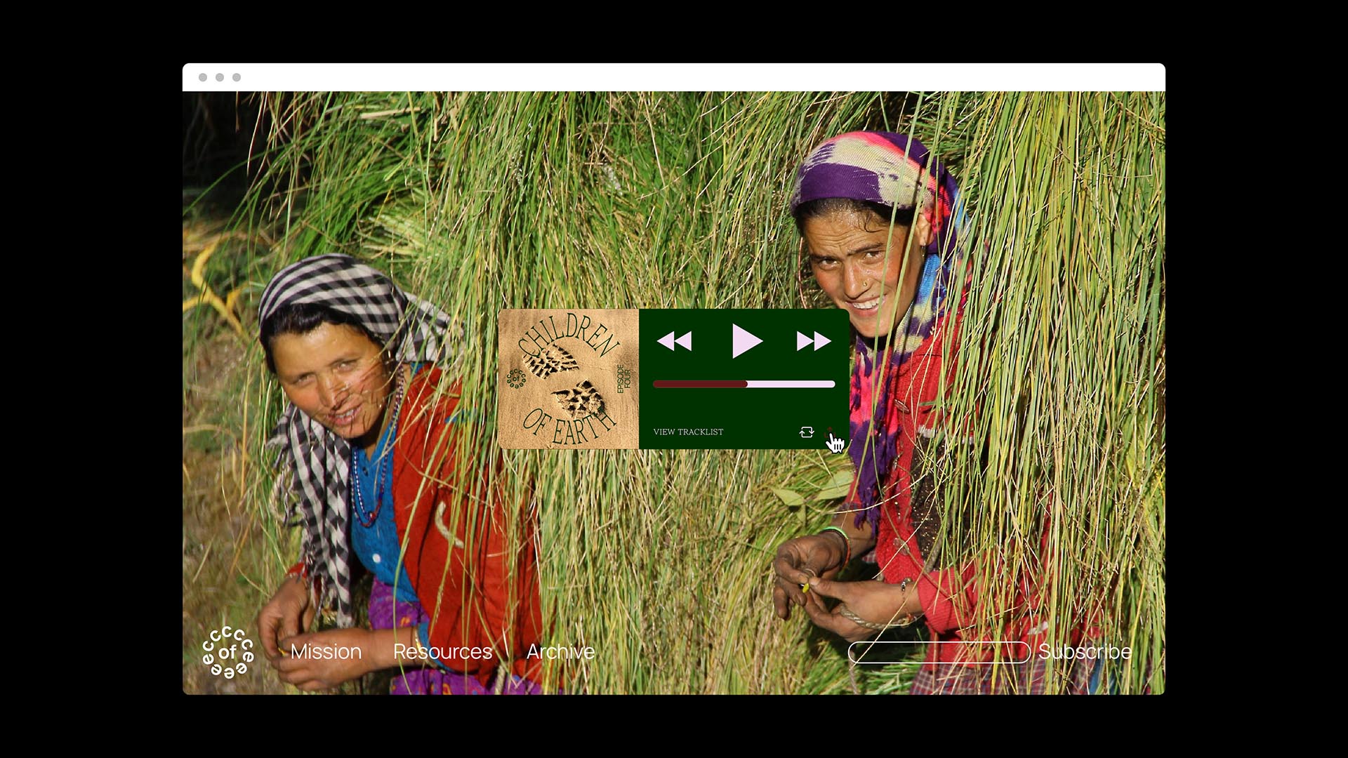 Two women are standing in a field of tall grass. The woman on the left wears a black and white checkered headscarf and a red top. The woman on the right wears a multicolored headscarf and a red top. A green music player window displays a song titled “CHILDREN OF EARTH” with a play button and progress bar. The bottom of the window shows “VIEW TRACKLIST” and “Subscribe.” A small circular icon labeled “Mission” is visible in the bottom left corner.
