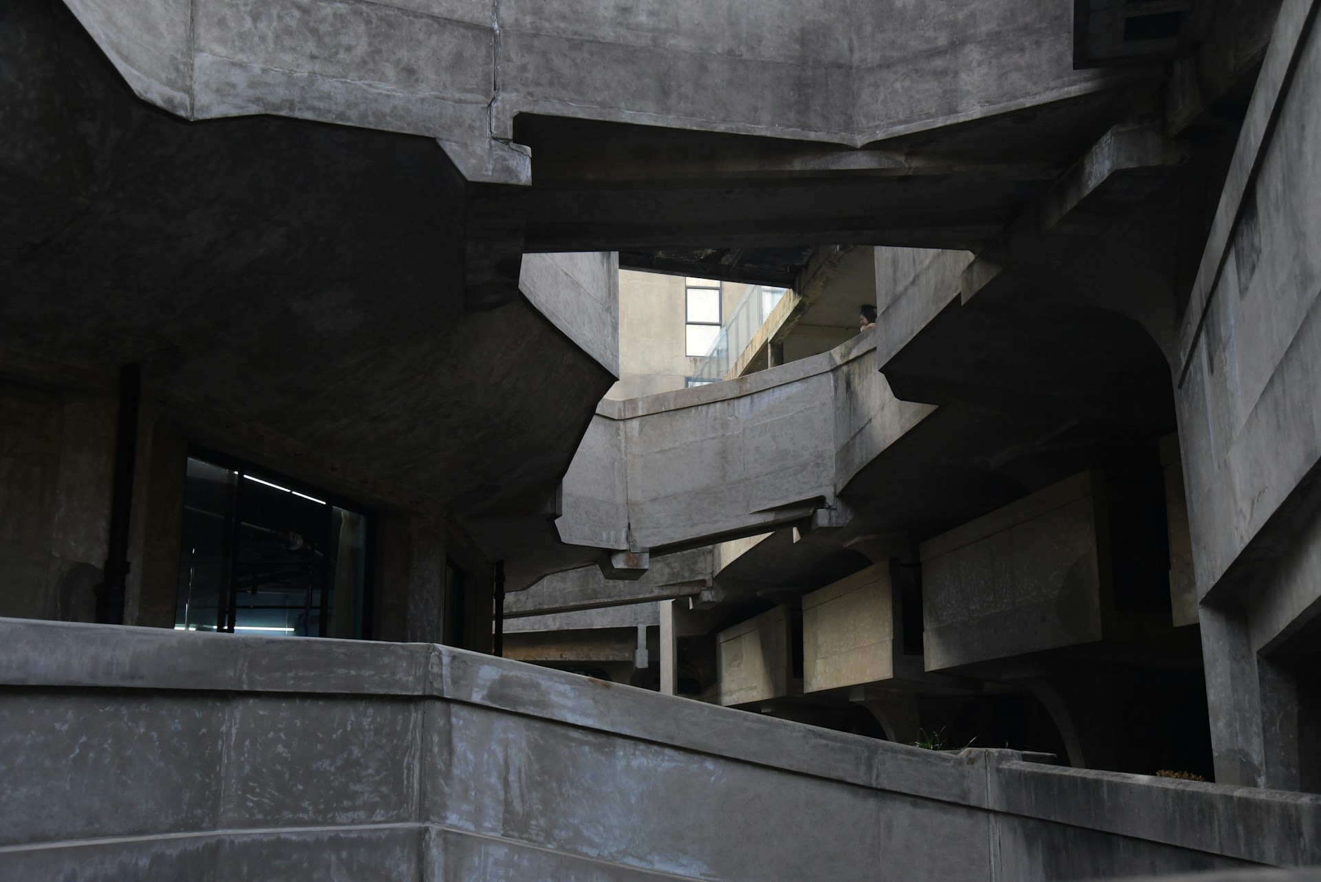 Raw concrete architectural structure with overlapping geometric planes and industrial minimalist design