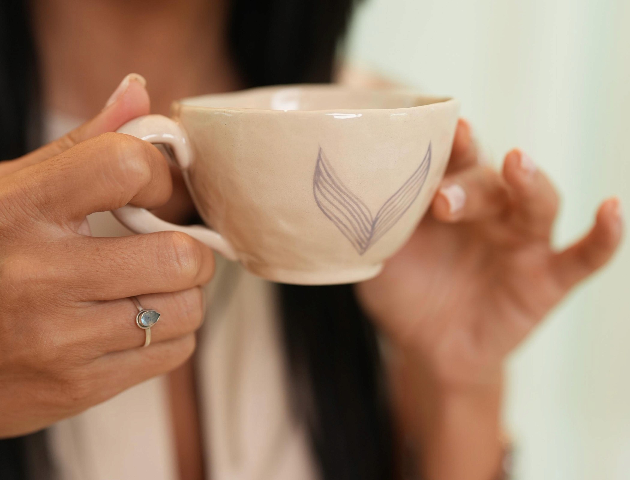Close up of hands holding a Voyex cup