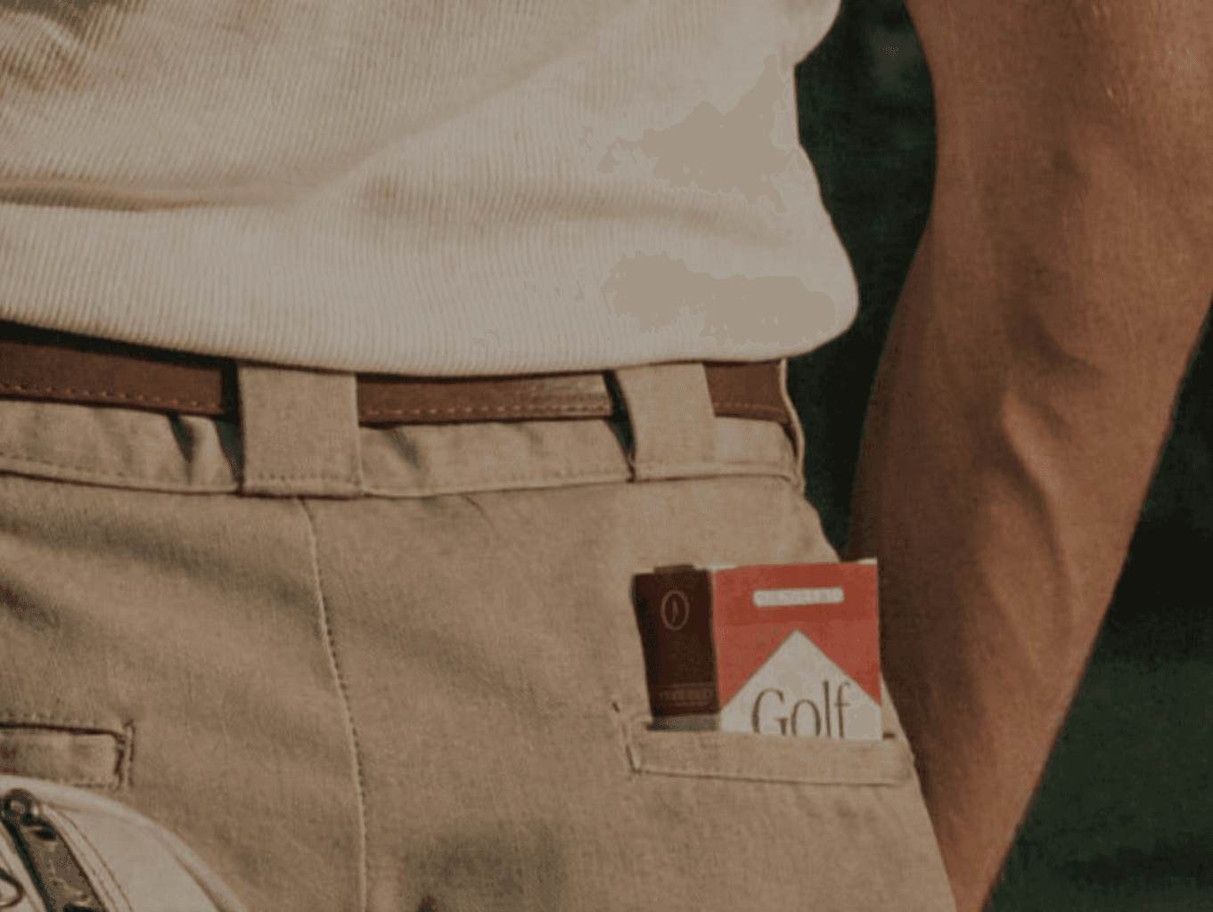 Man dressed in dark casual wear sitting alone in a stadium’s empty rows of purple chairs, lit by dramatic moody lighting.