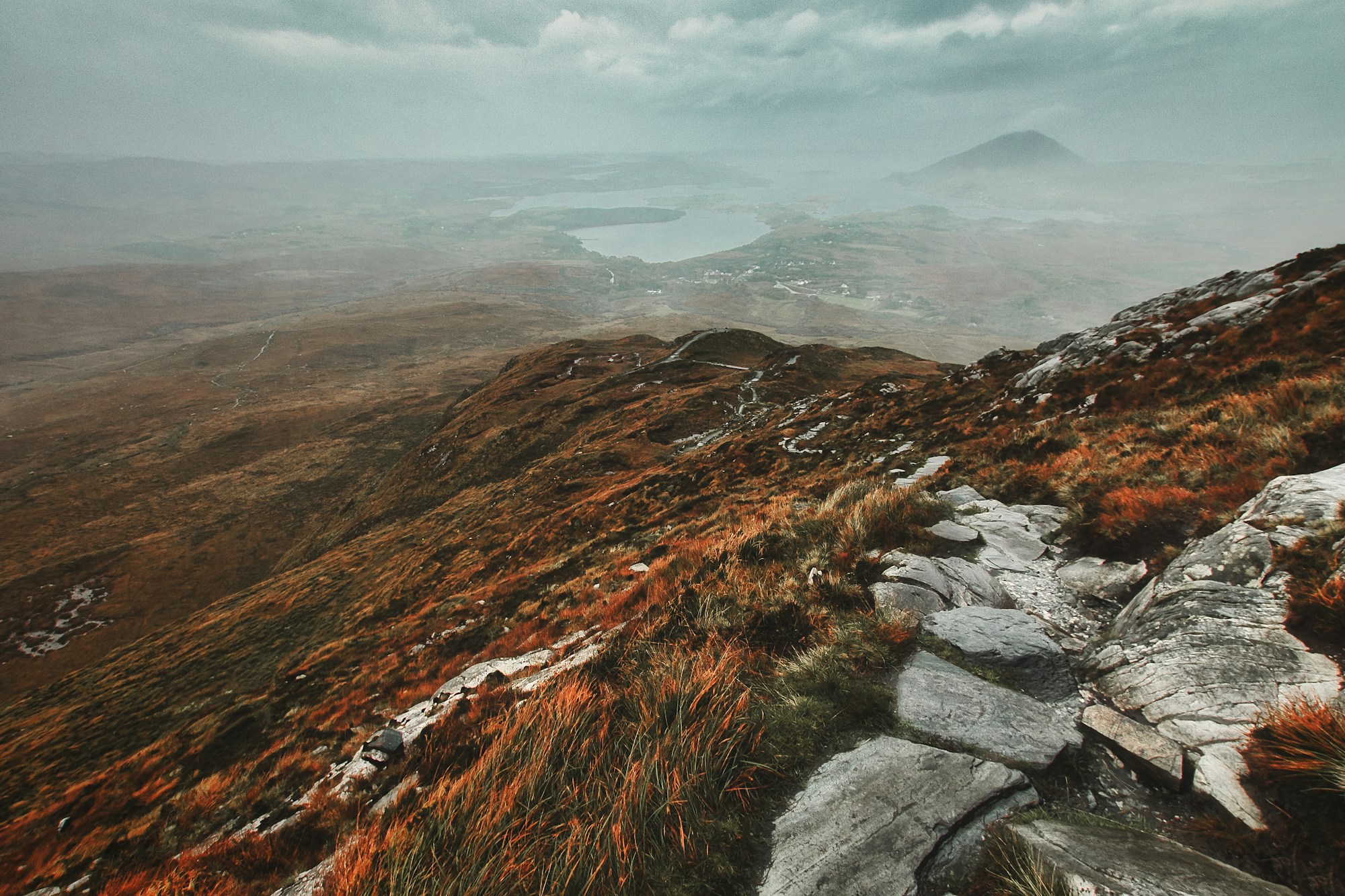 A rocky path climbing above a misty valley