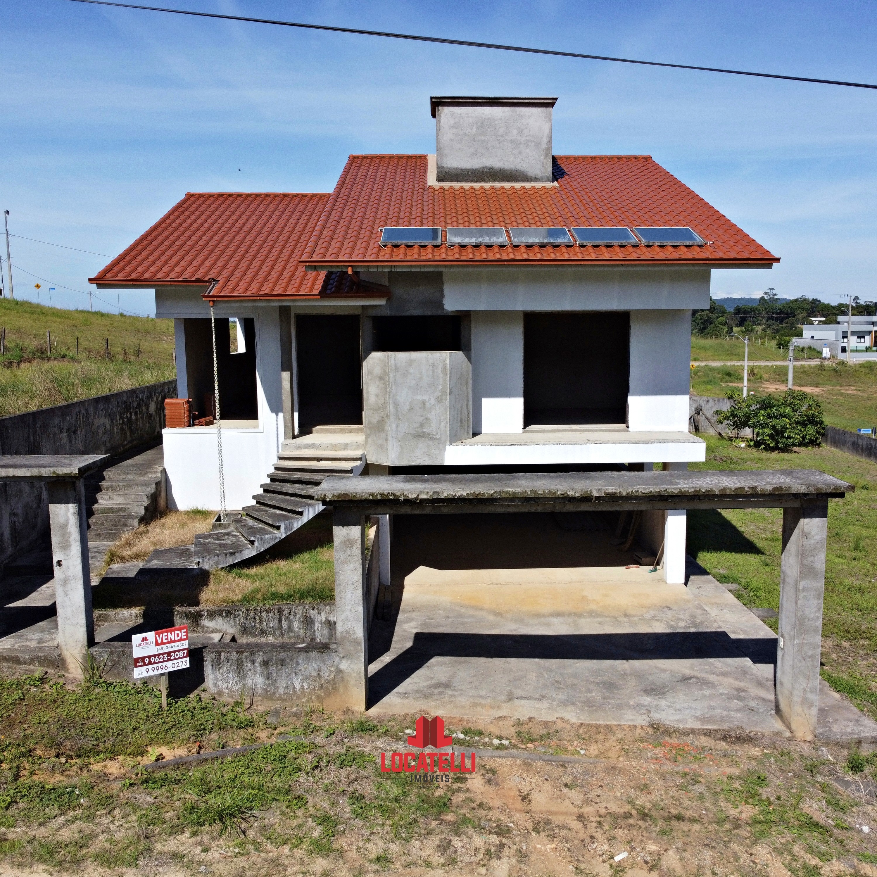 A modern brick house with a two-car garage, well-manicured lawn, and clear blue sky in the background.