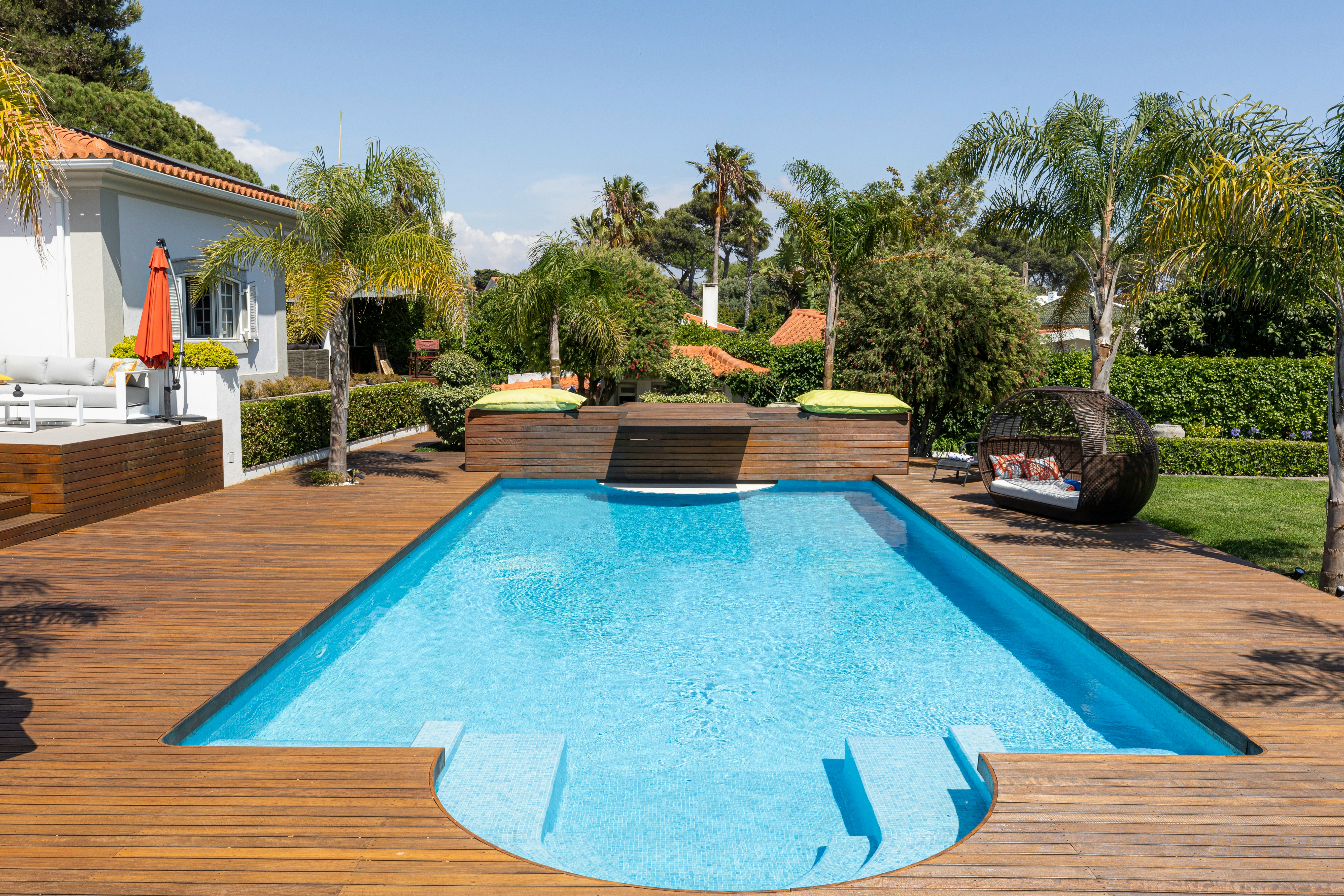 A luxurious swimming pool sits in a backyard.