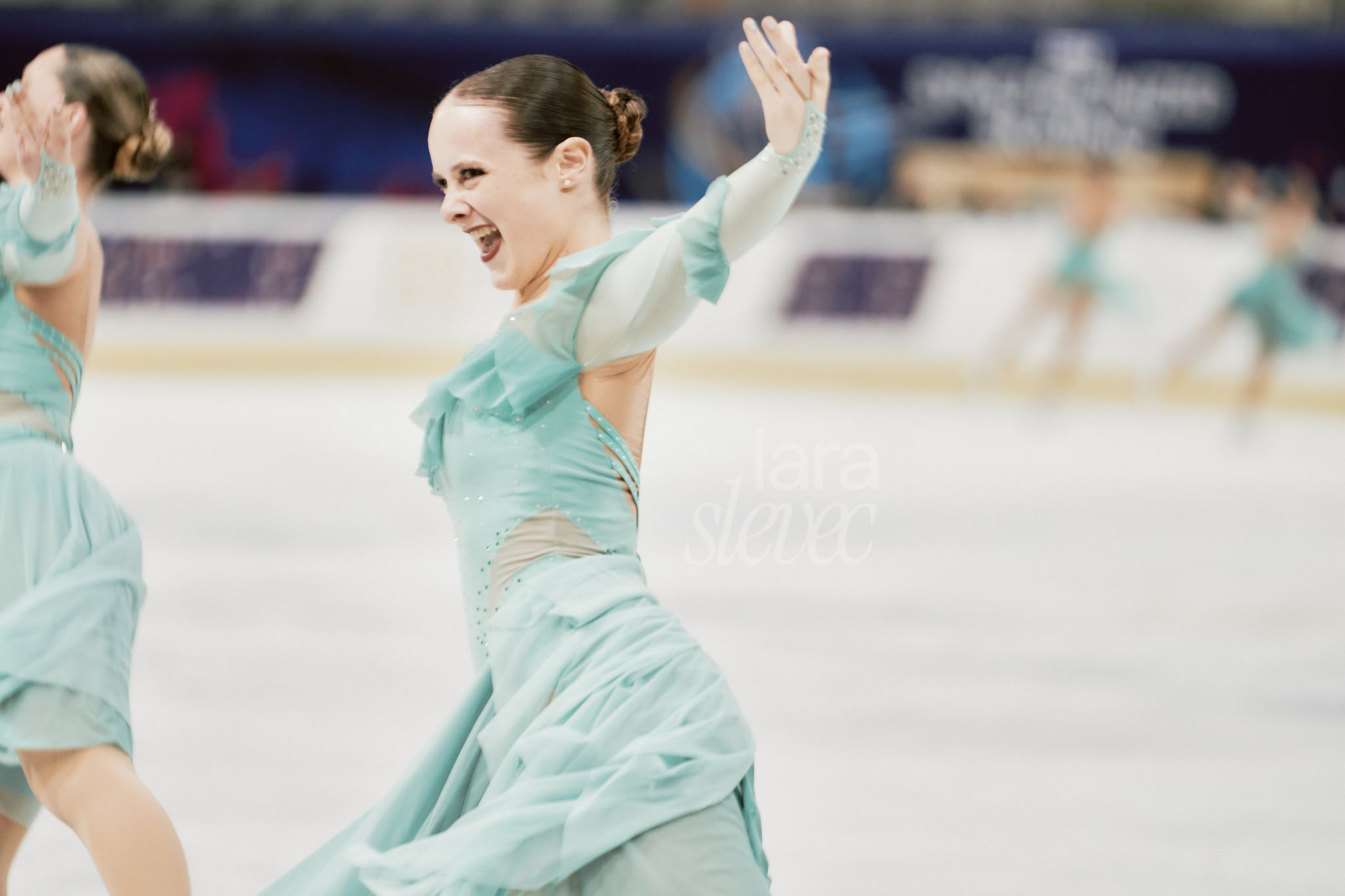 Läuferin des Teams Cool Dreams in der Kür. Eiskunstläuferin in voller Fahrt in mint farbenem Kostüm. ISU Synchronized Skating Championships 2026 in Salzburg. Fotografiert von Lara Slevec.