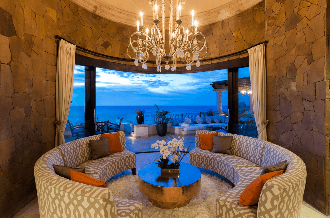 Curved lounge seating beside ocean-facing windows.