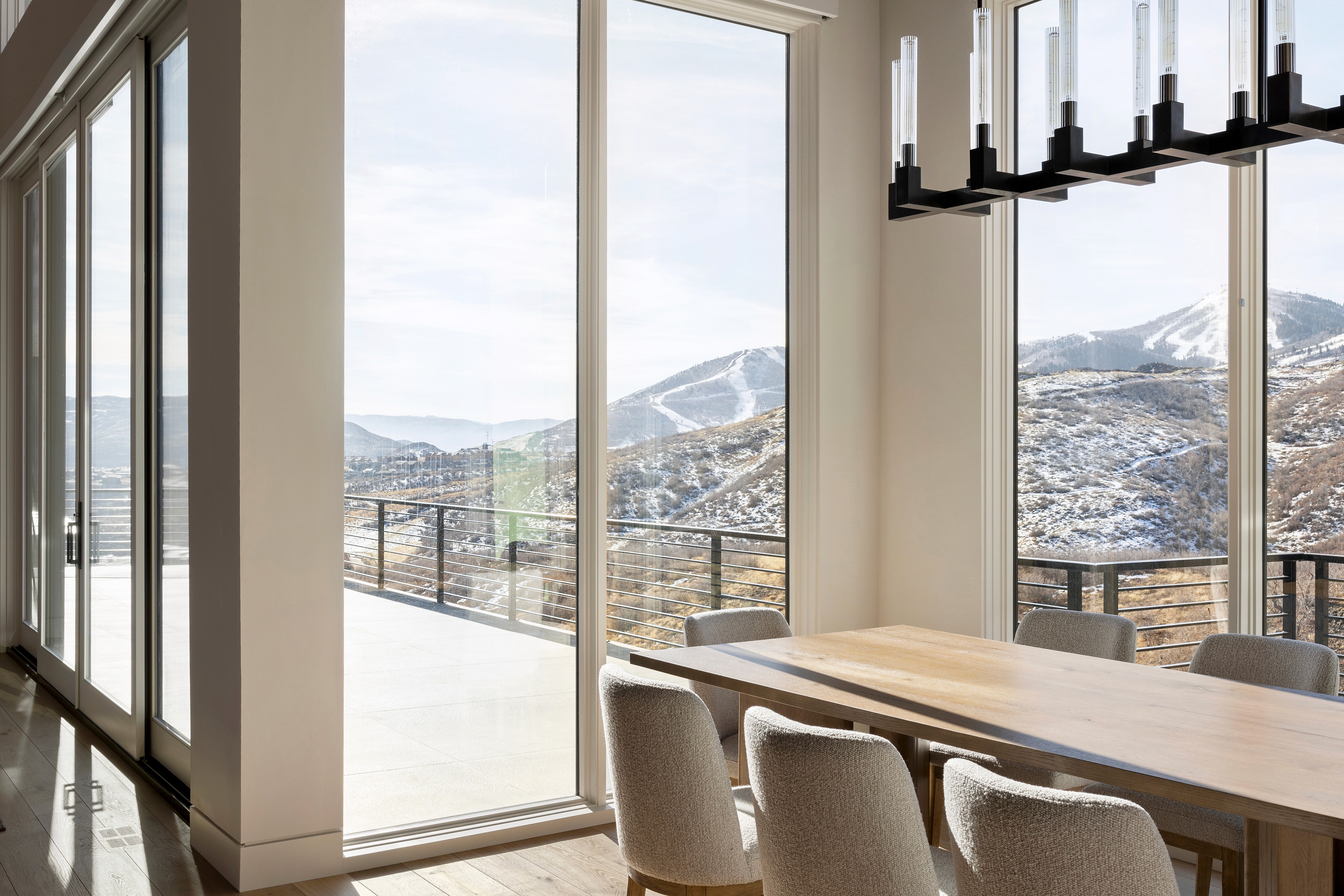 PhoModern mountain luxury home exterior with floor-to-ceiling windows and stone masonry in Park City, Utah, built by Vitruvius Builtto