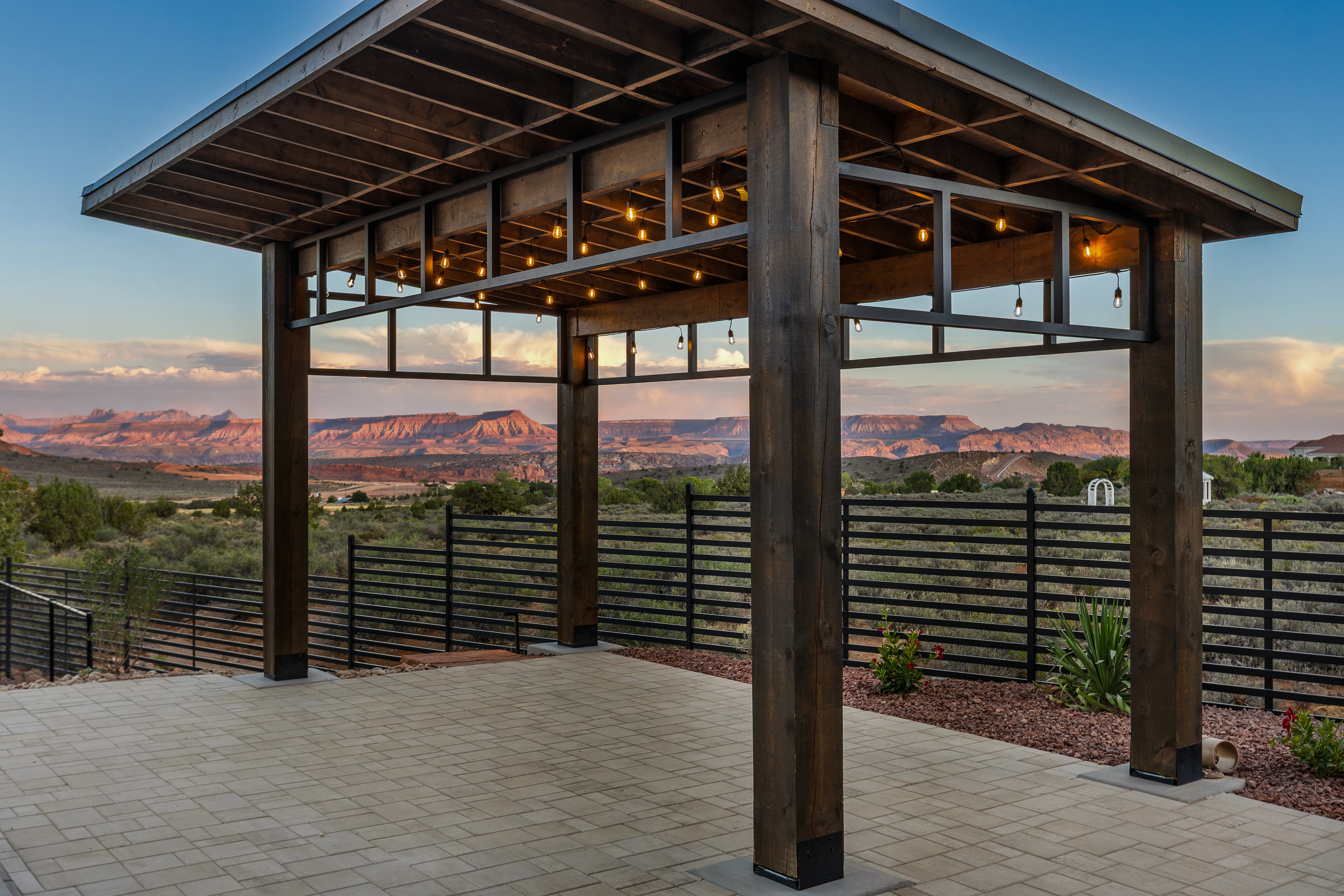 Covered patio structure with string lights and desert views in a Leeds, Utah backyard.