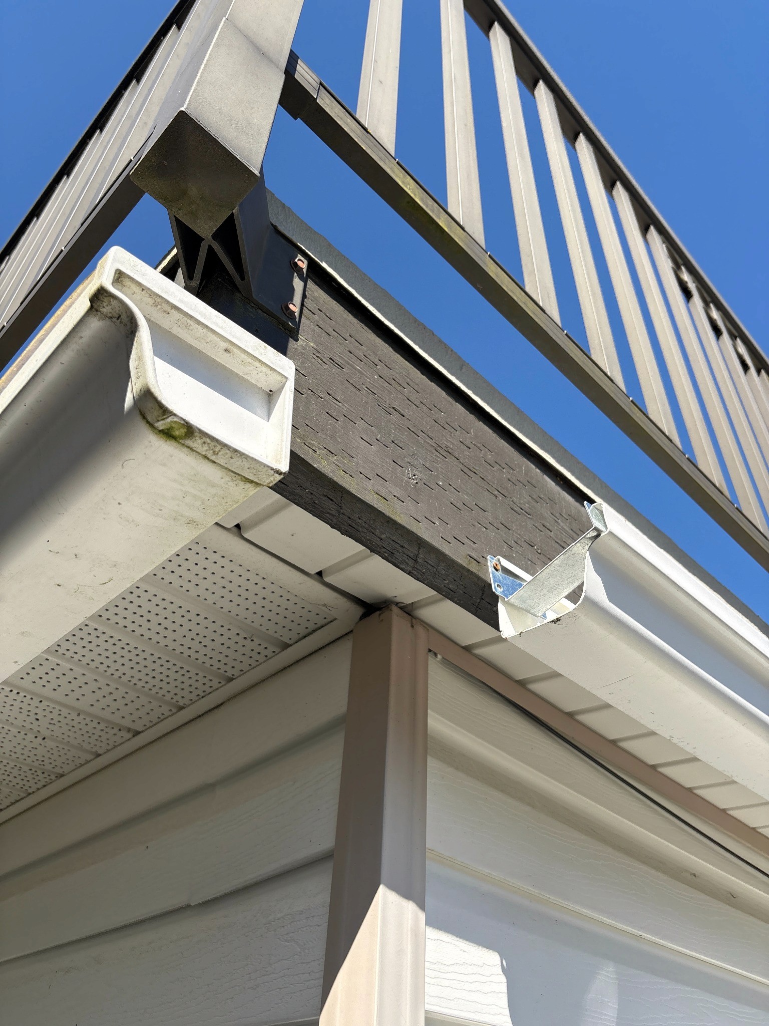 Existing fascia and gutter area beneath an elevated deck before repair.