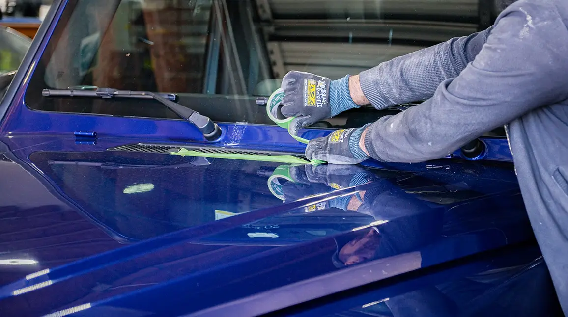 Auto Body Unlimited technician polishing vehicle paint during final repair finishing.