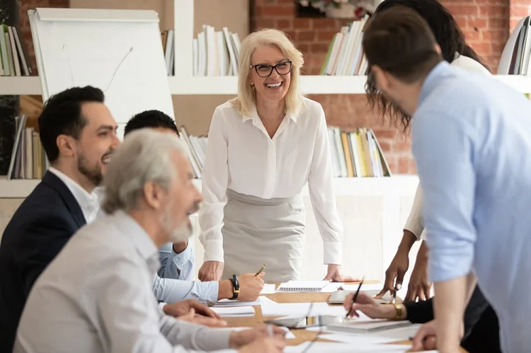 Team collaboration meeting at Alberts & Gabriel, showcasing a diverse group of professionals discussing sales enablement strategies in a modern office setting.