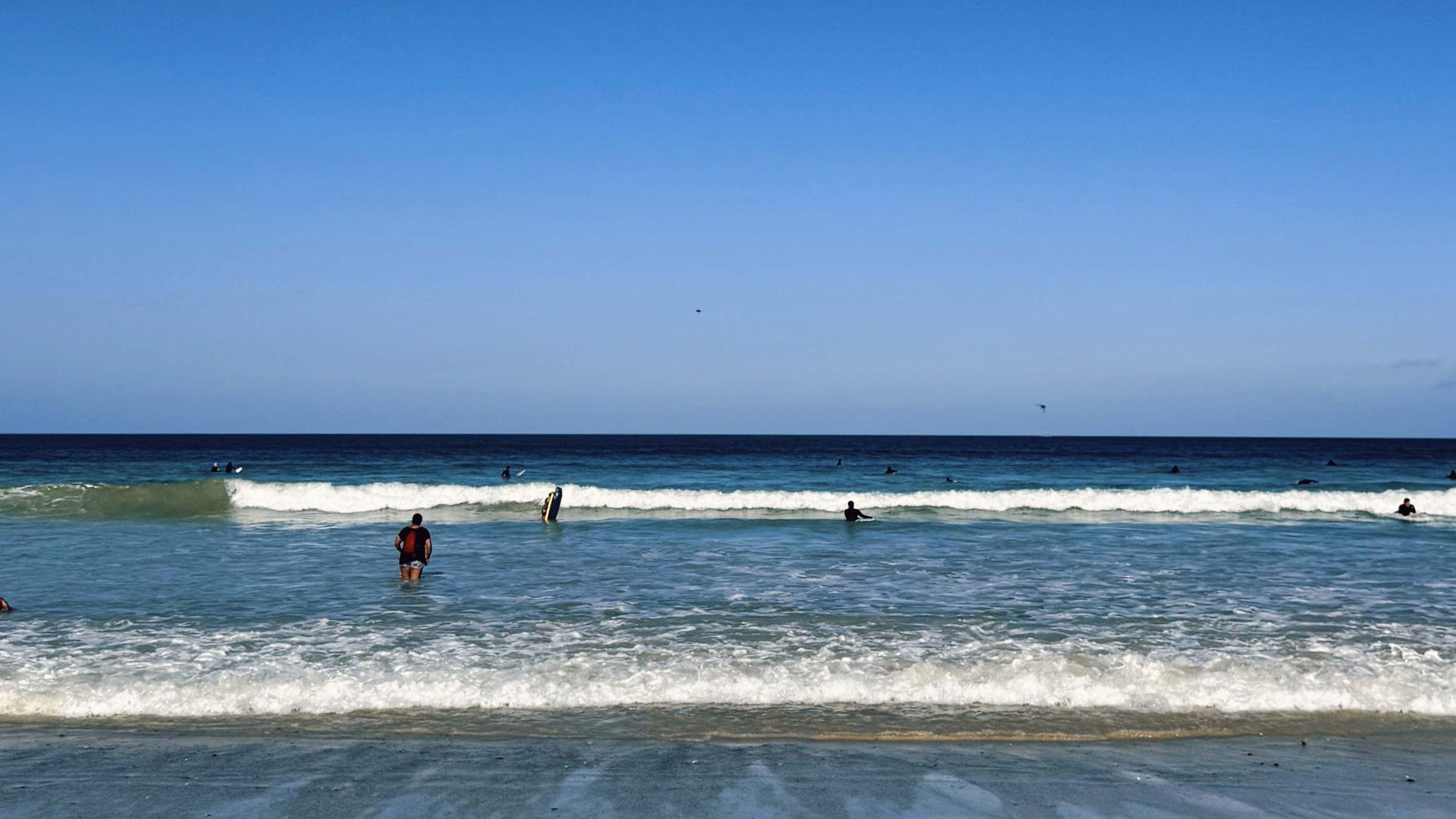Muizenberg beach in Cape Town, showing surfers and swimmers in the water 