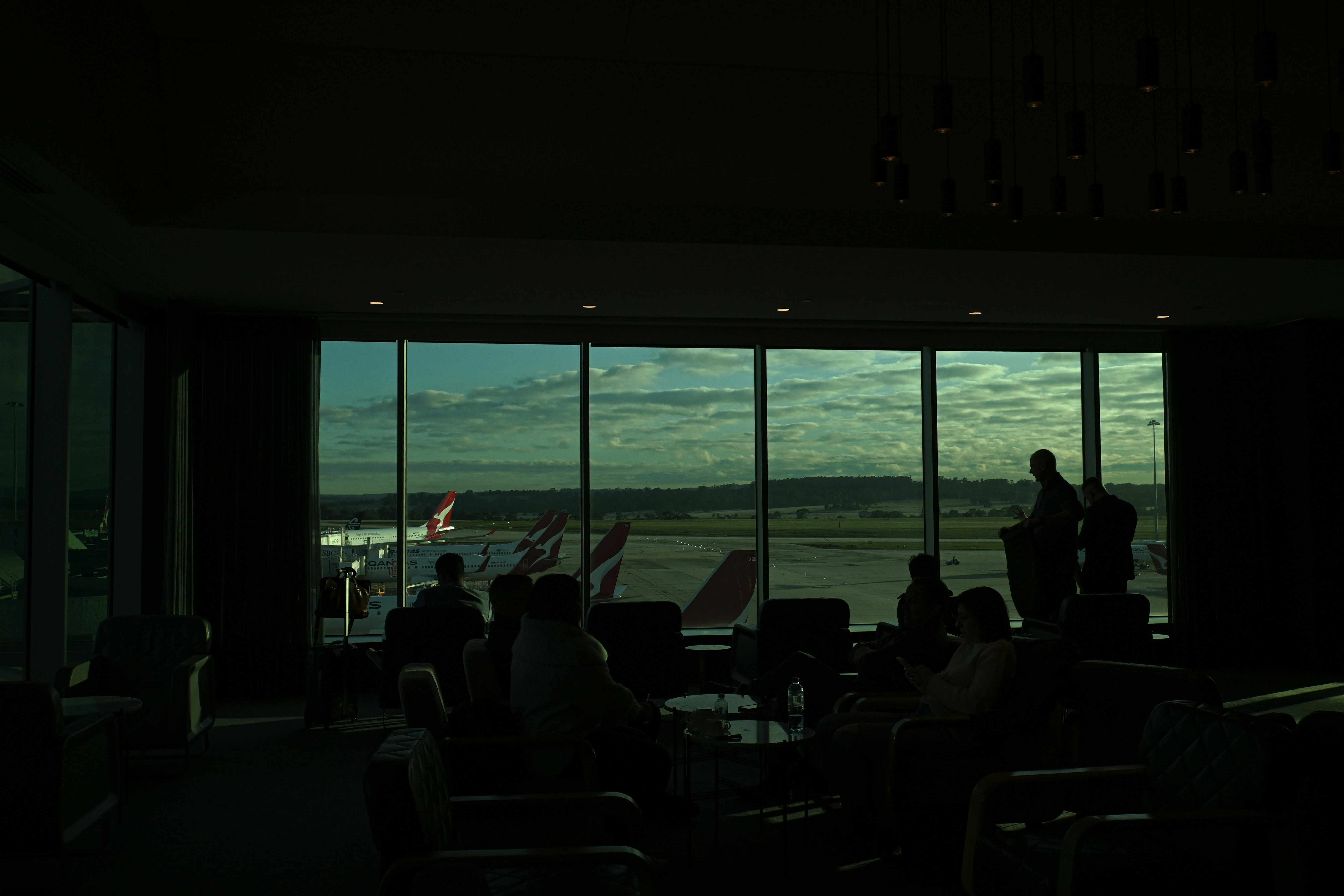 people sitting at tables in a room with large windows looking out to the water
